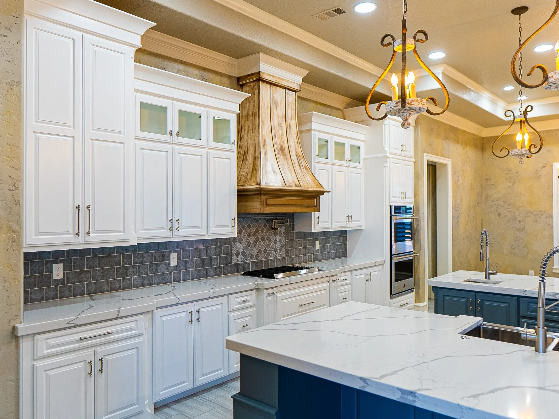 White perimeter cabinetry with a hand-painted wood vent hood and gray tile backsplash at 1501 NW 12th St