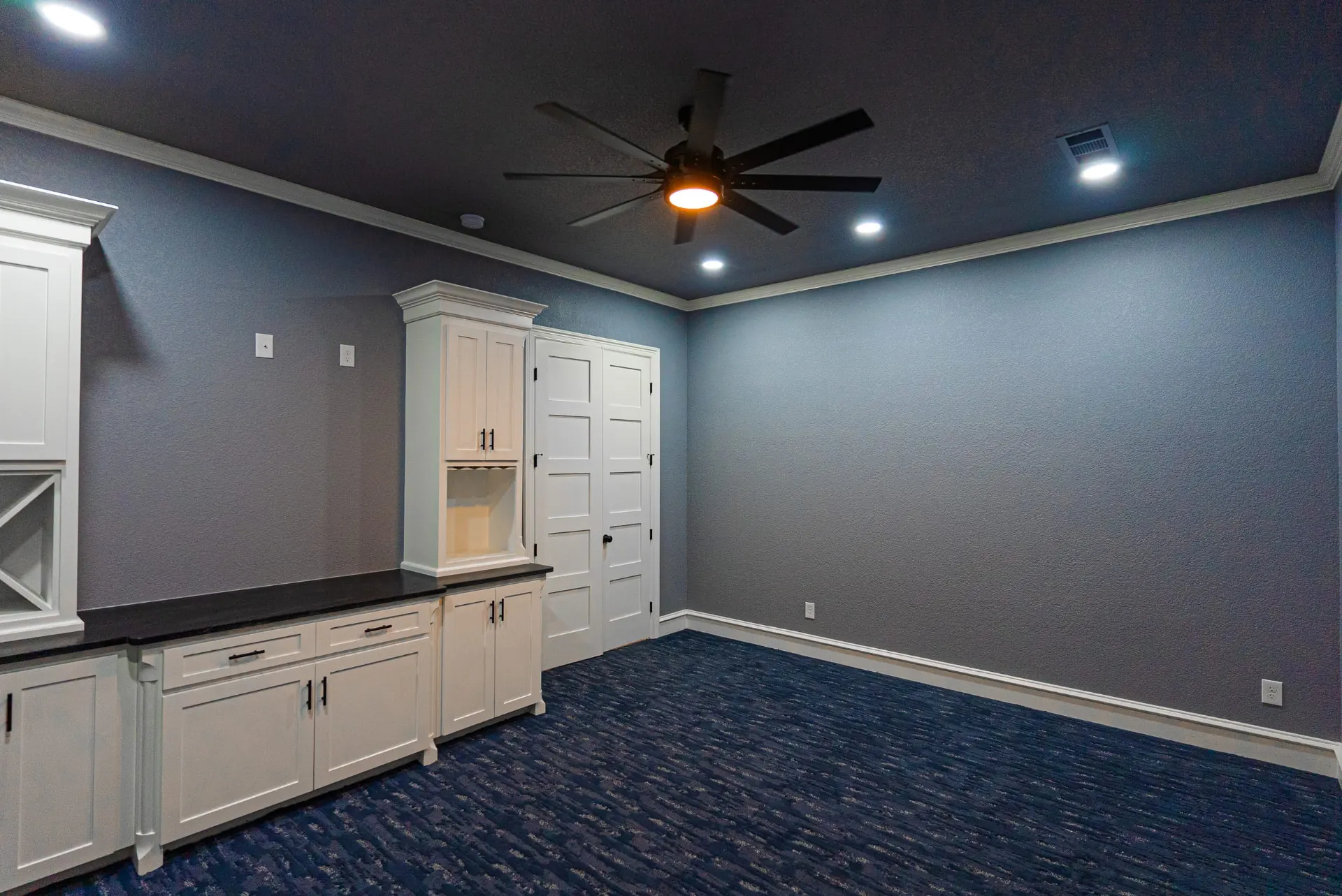 Media and game room at 1602 NW 12th St with white built-in cabinets, wine racks and black granite bar top