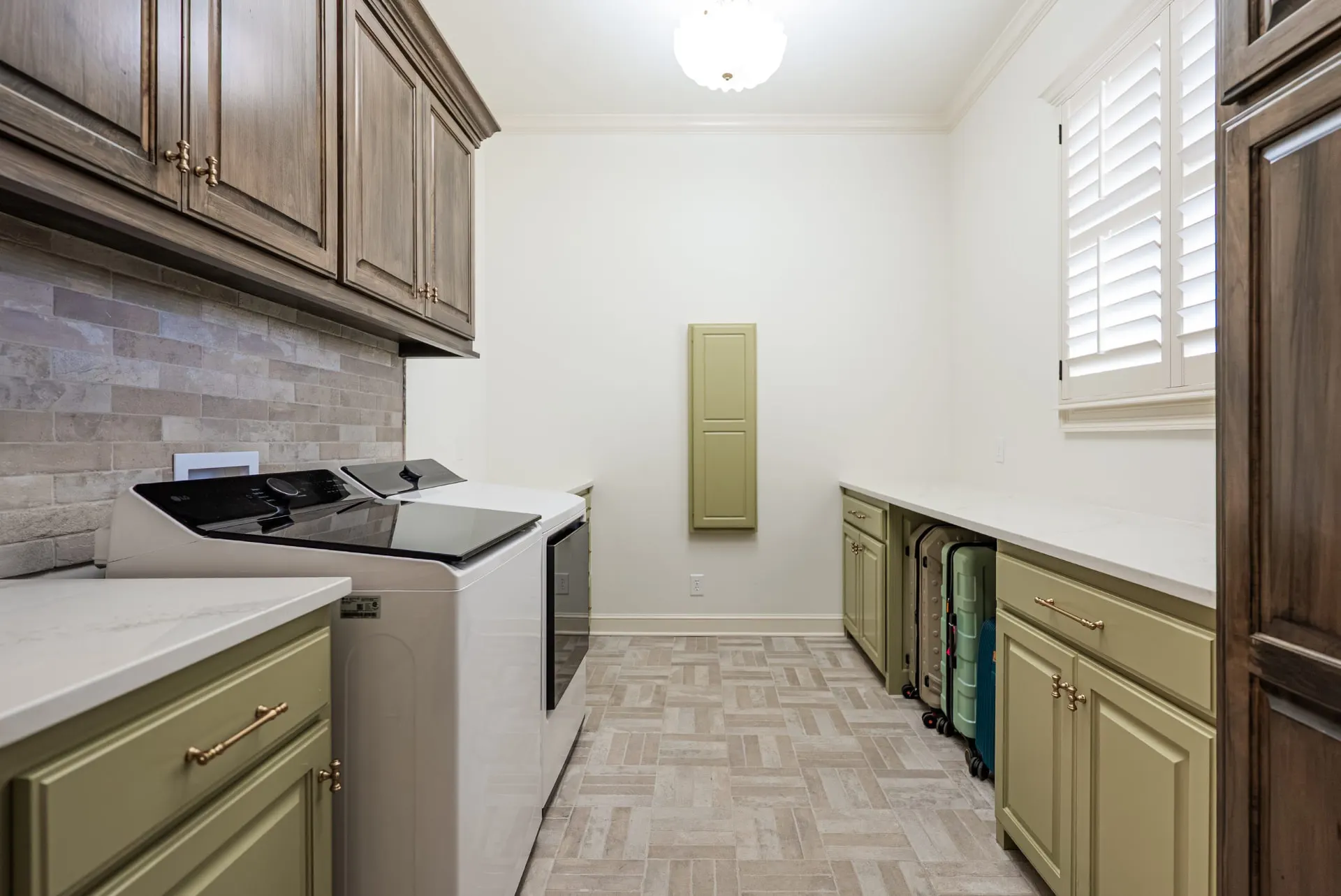 Laundry room at 1610 NW Eliam Dr with sage green cabinetry and a wall-mounted ironing-board cabinet