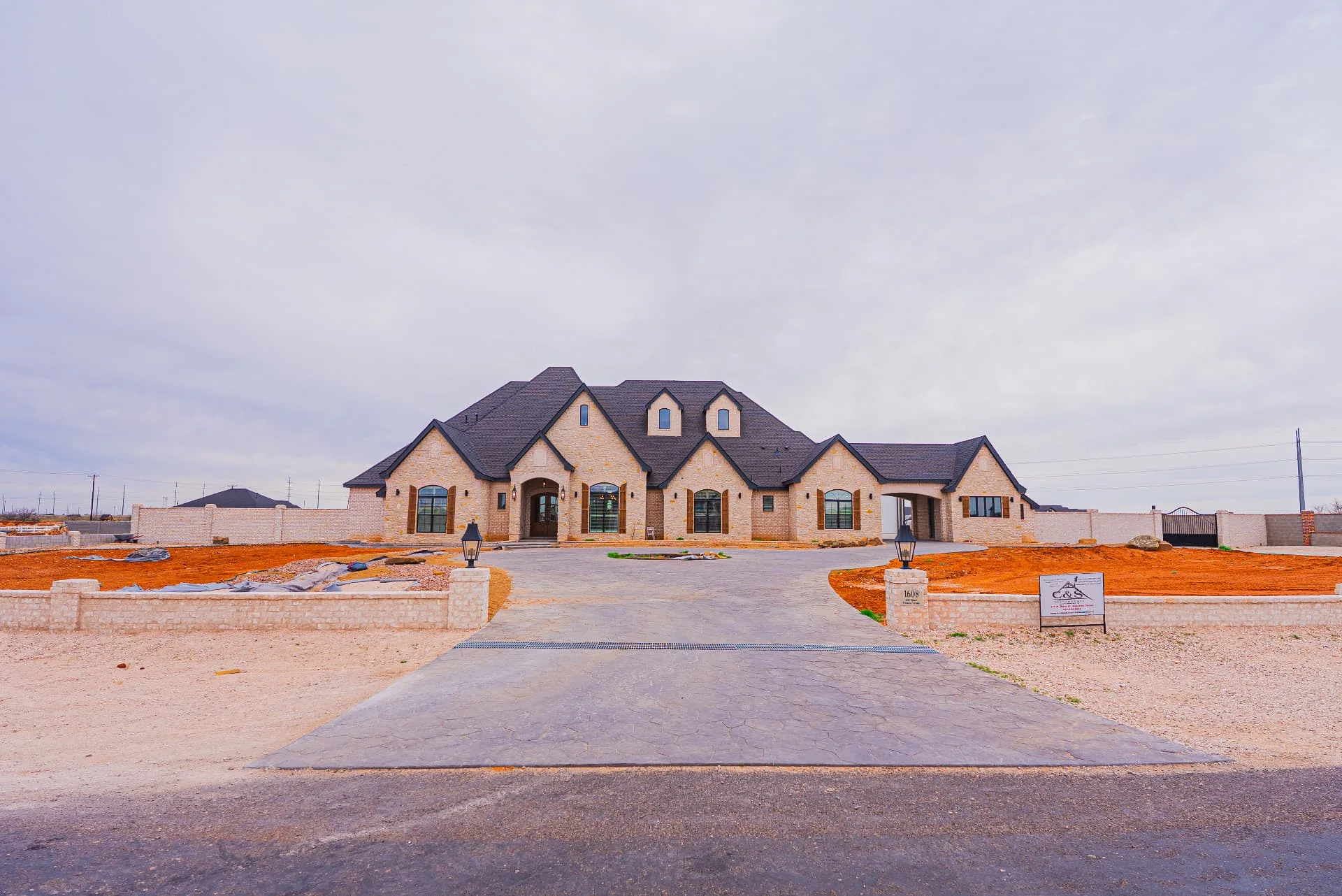 Front approach to The Flores Estate with multi-gabled stone facade