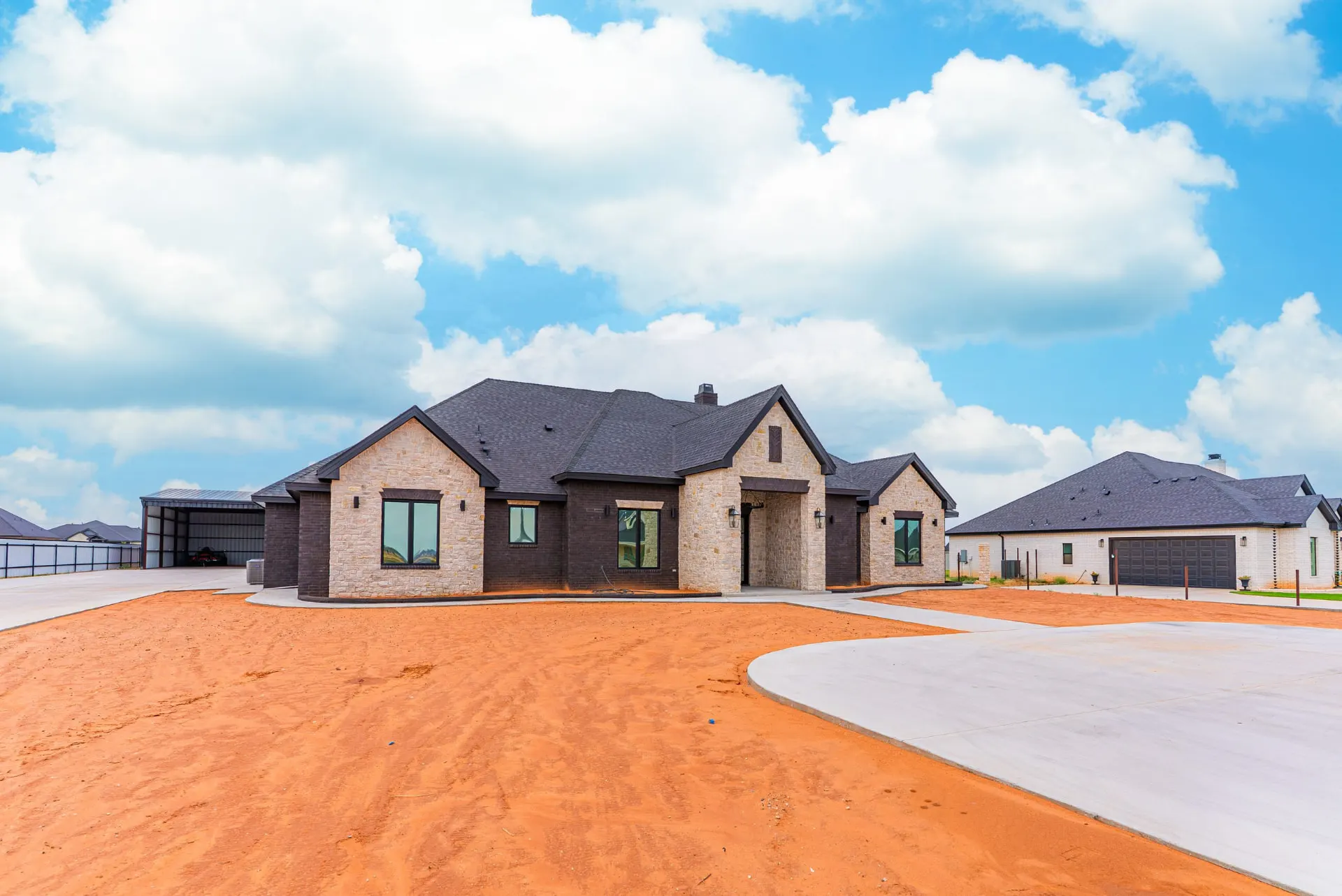 Three-quarter front view of 1607 NW 12th St with stone gables and a circular concrete drive