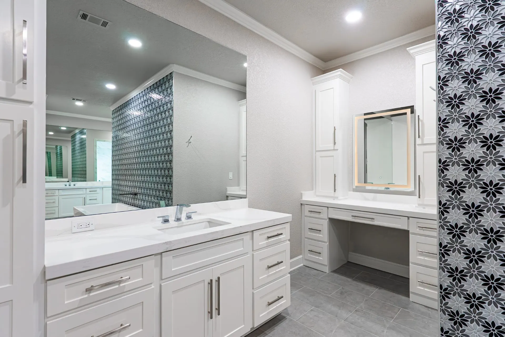Primary bath vanity with quartz top and a lit makeup-desk mirror at 27 Santiago Mission Dr