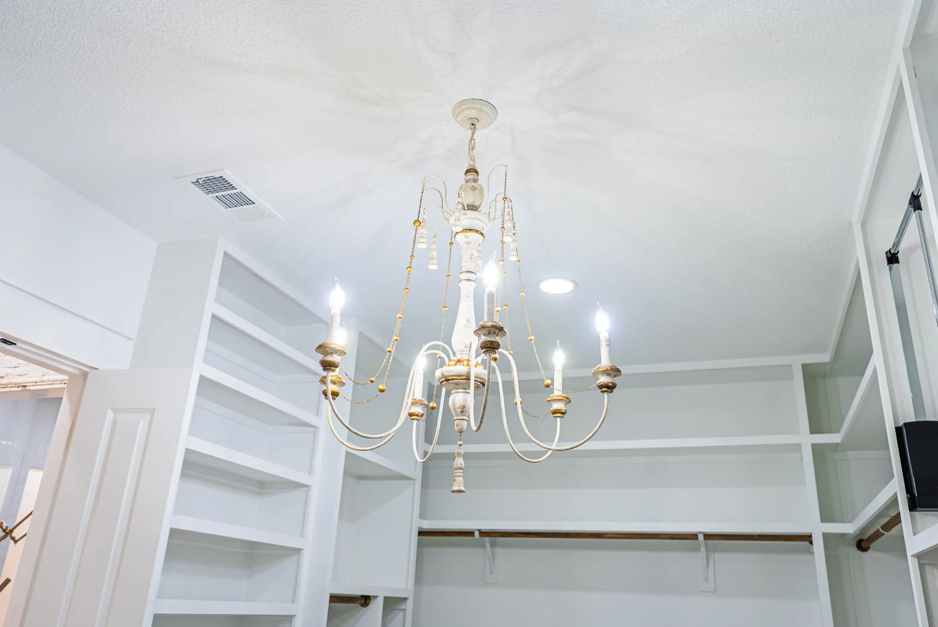 Whitewashed wood-and-gold chandelier in the walk-in closet at 1607 NW 12th St