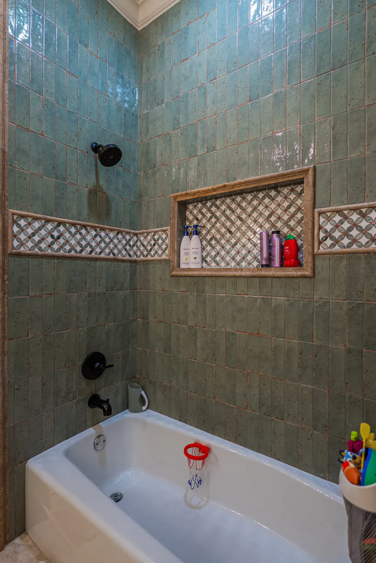 Tub-shower at 1610 NW Eliam Dr with sage handmade tile and a mosaic border and niche