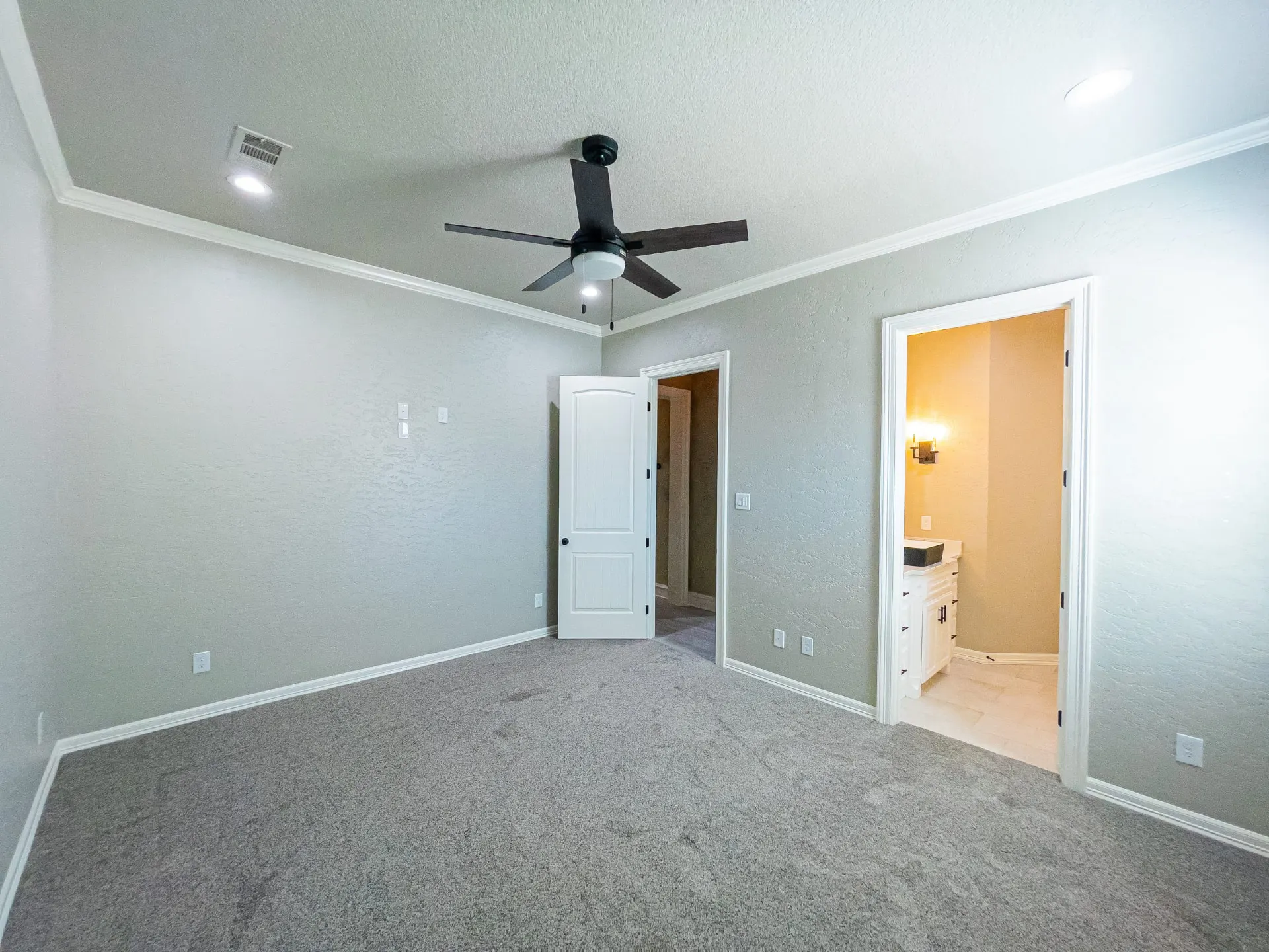 Carpeted guest bedroom with ceiling fan and private bath at 1501 NW 12th St