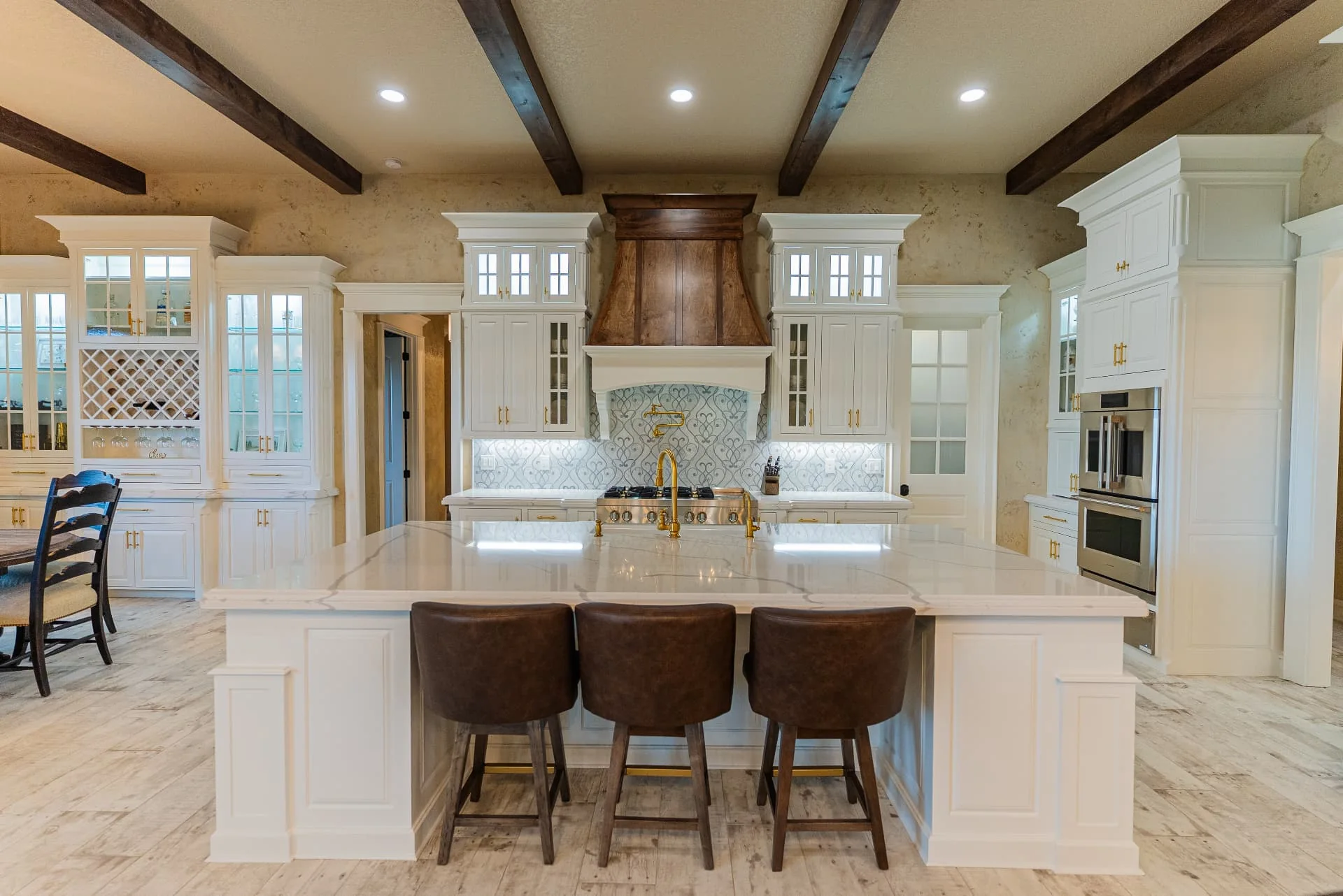 Kitchen at The Flores Estate with white island and dark ceiling beams