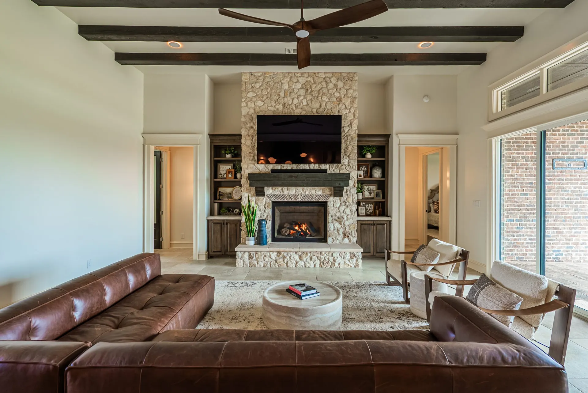 Floor-to-ceiling stone fireplace with built-in bookshelves in the great room at 1610 NW Eliam Dr