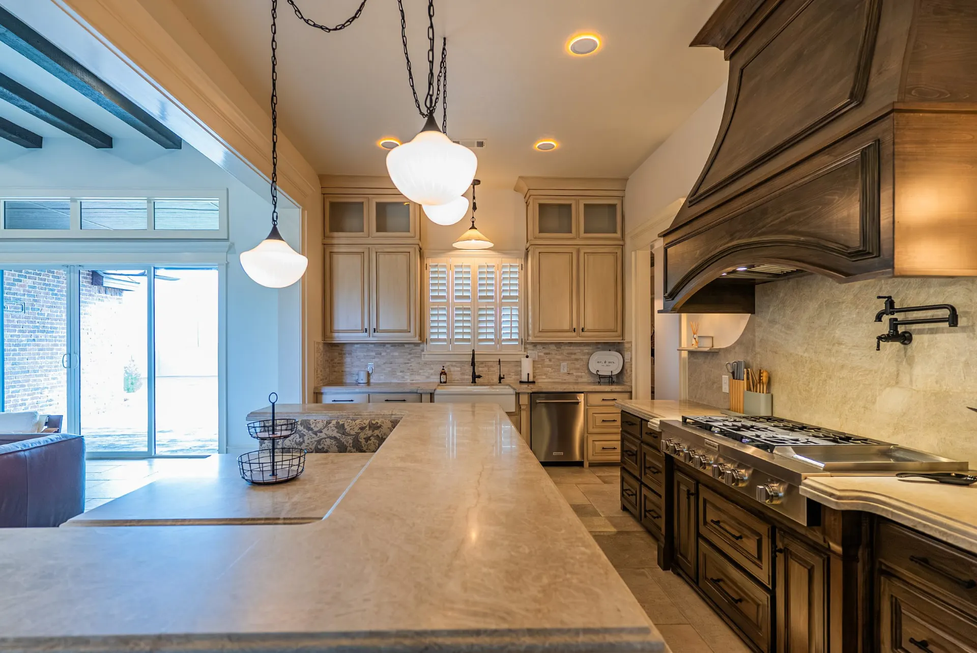 Professional gas range under a carved wood hood at 1610 NW Eliam Dr
