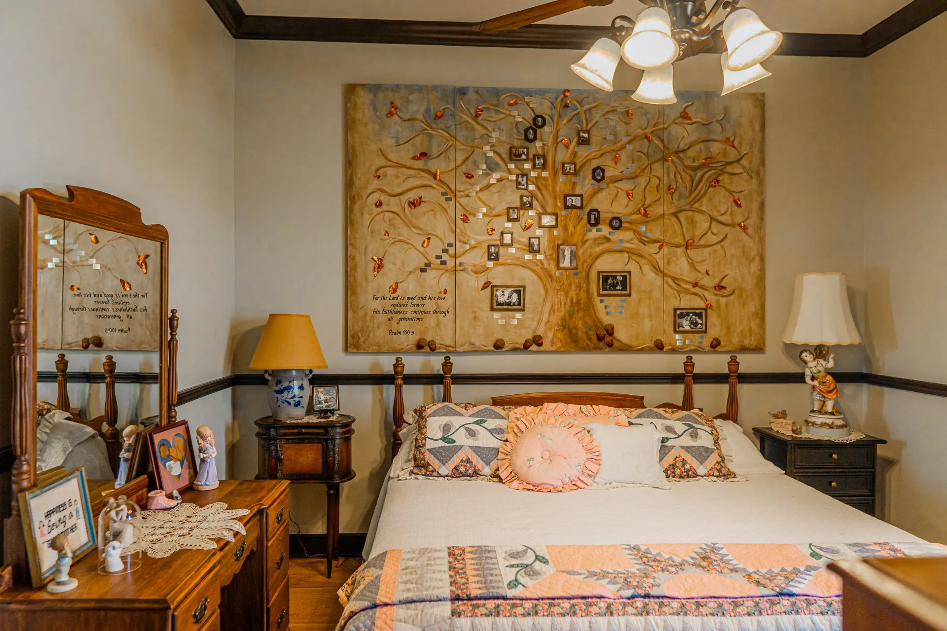 Second angle of the family-tree mural bedroom at the Wraparound Porch Home, showing a mirrored vanity, rocker and antique nightstand
