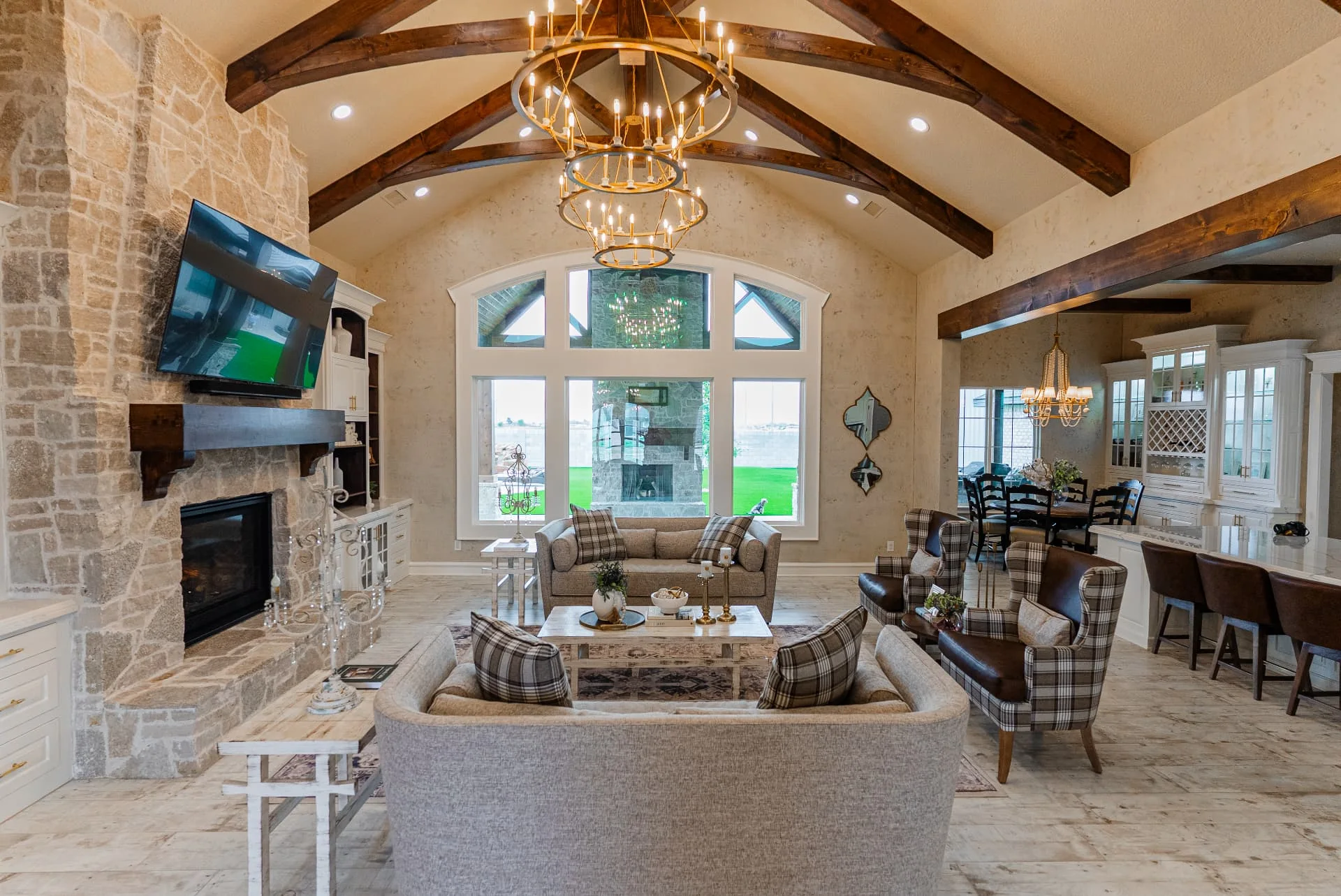 Living room at The Flores Estate with stone fireplace, vaulted beams and chandelier