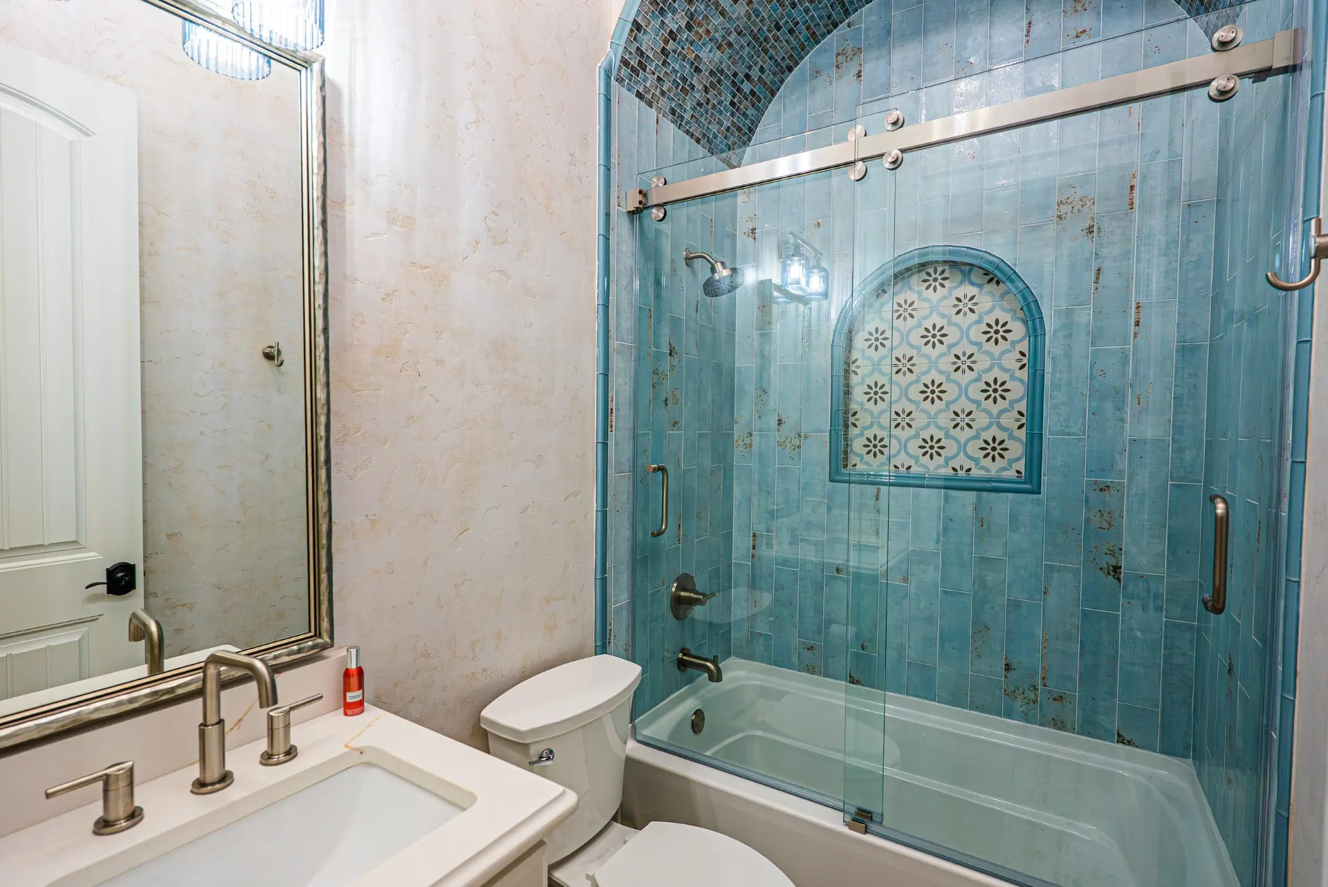 Guest bath at 5 Prairie Ln with blue tile shower and arched niche