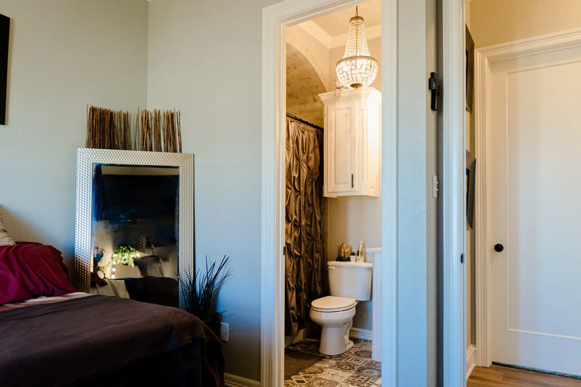 Bedroom at 8821 Shawn Dr opening to an ensuite with a barrel-vaulted brick-look ceiling and a crystal chandelier