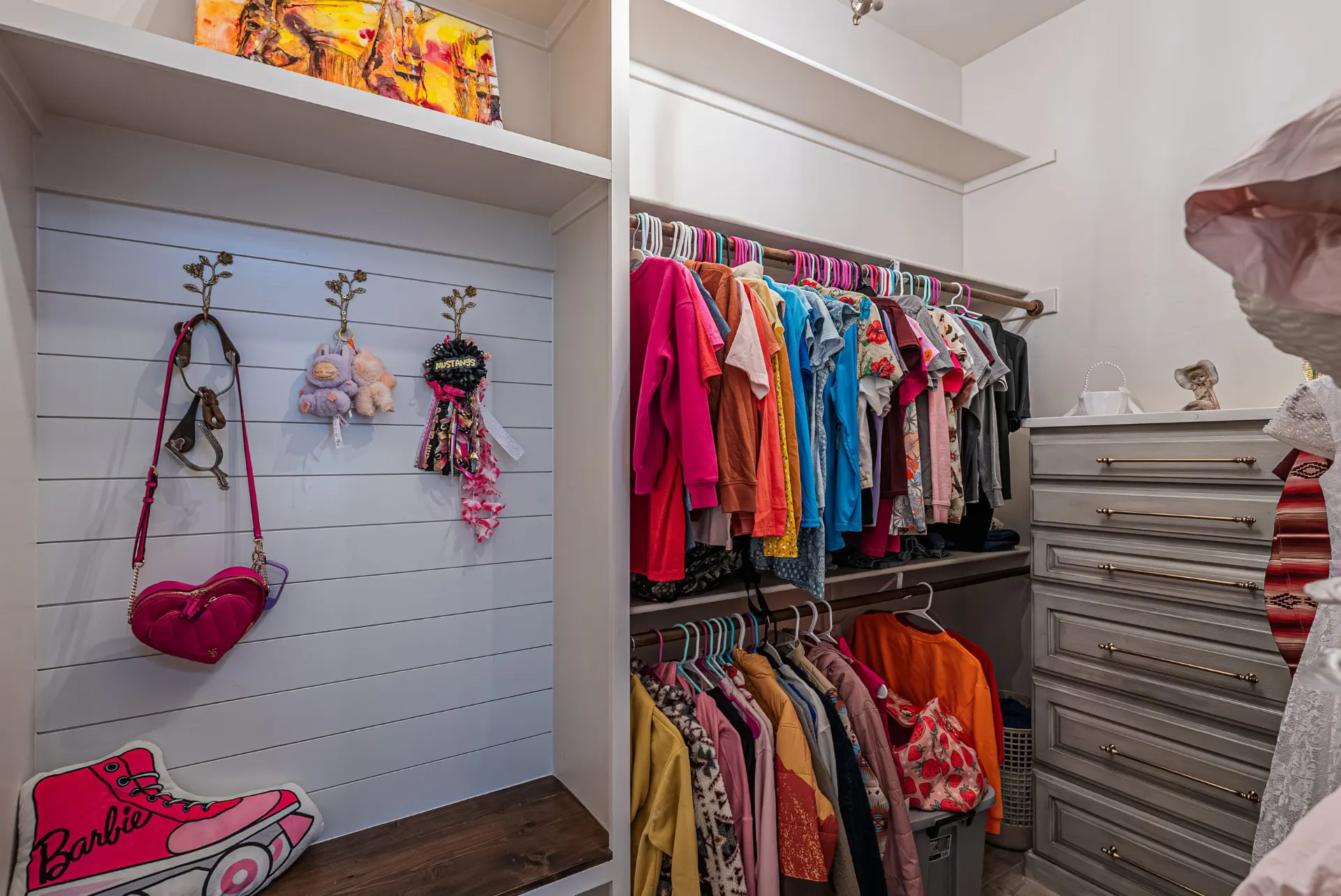 Walk-in closet at 5 Prairie Ln with shiplap walls and brass hardware