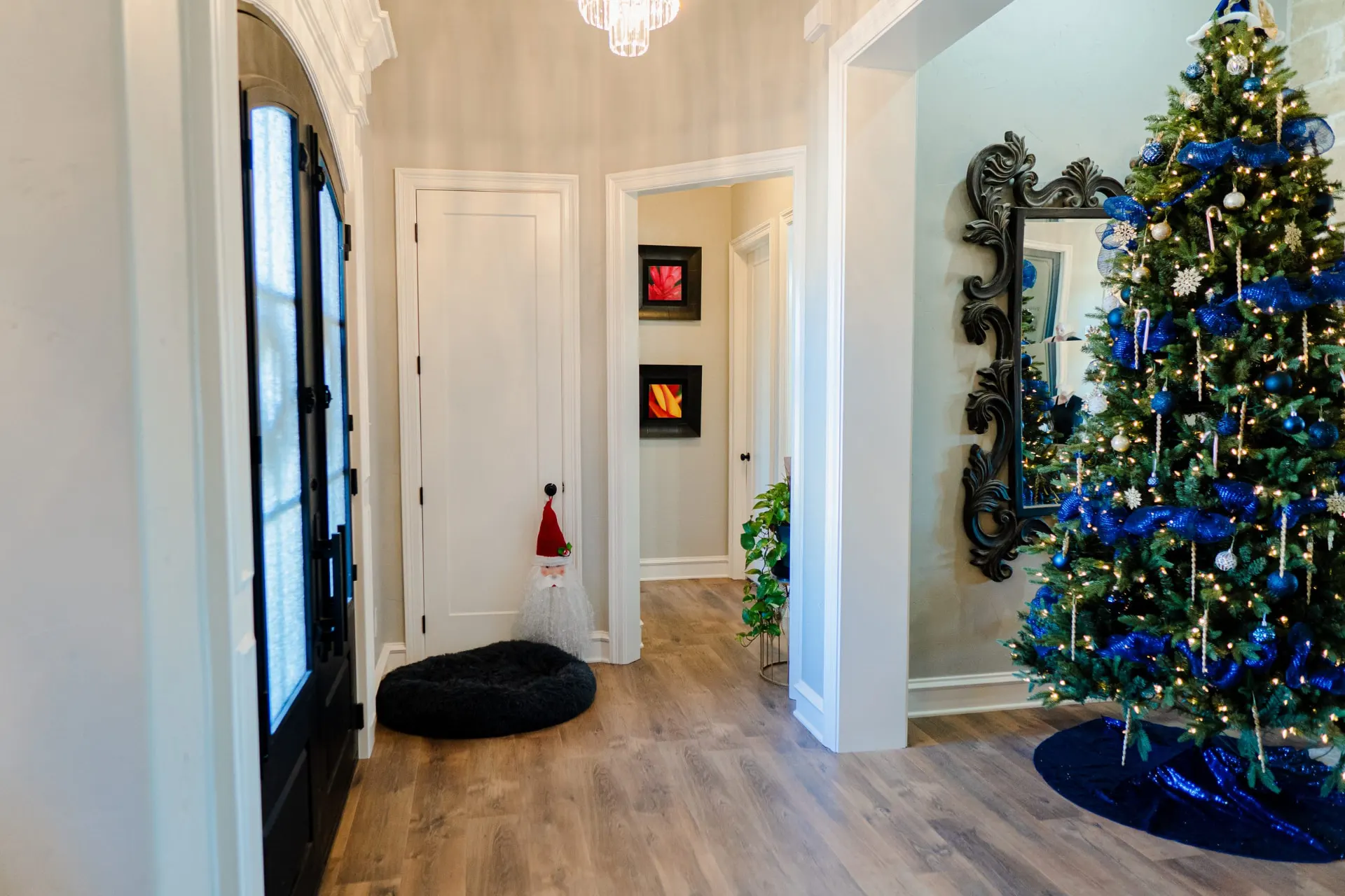 Entry at 8821 Shawn Dr with arched black double doors, a crystal chandelier and wood-look flooring
