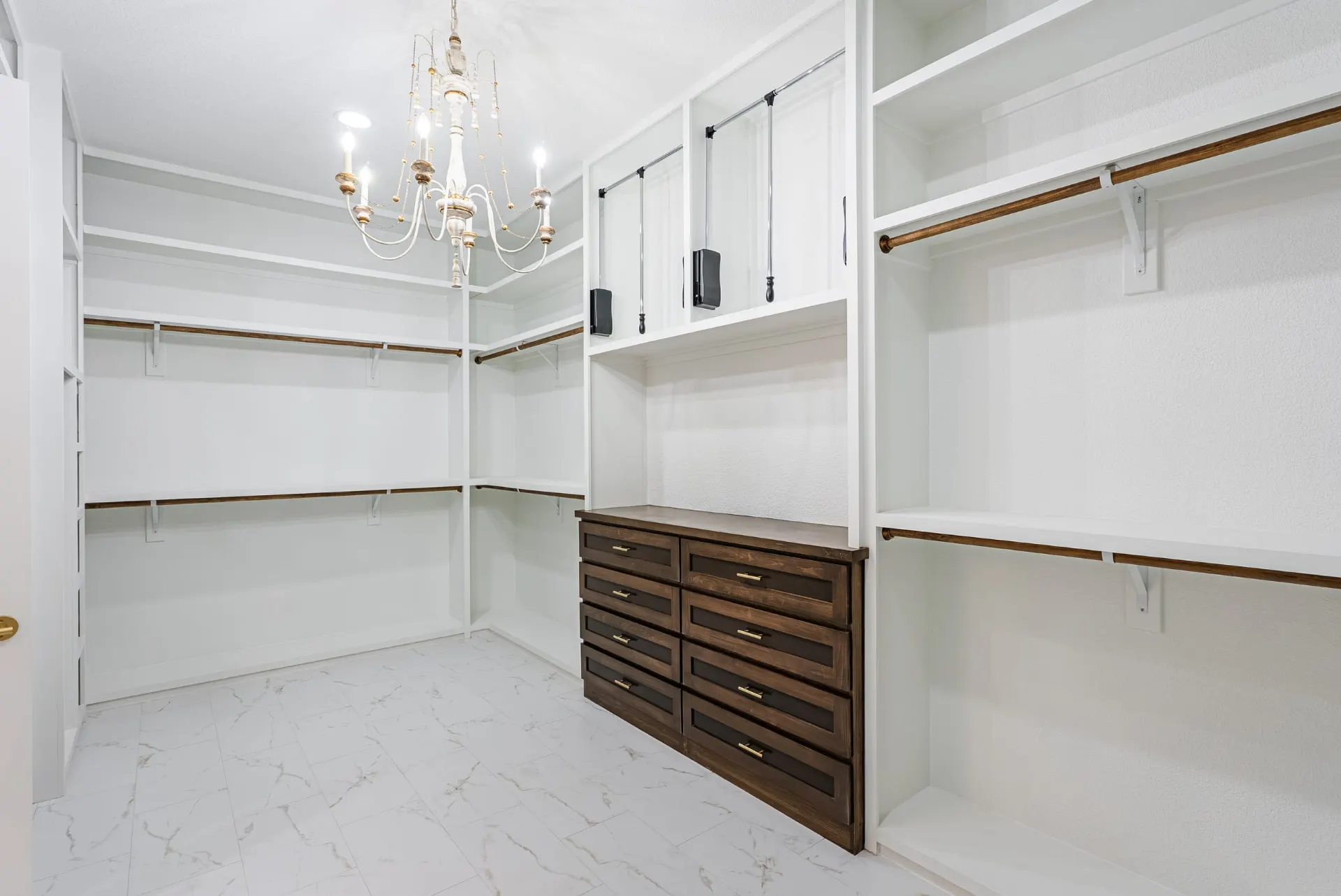 Walk-in closet with white built-ins, dark wood hanging rods and a stained dresser at 1607 NW 12th St