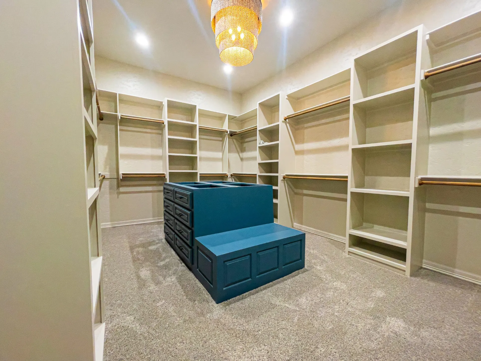 Primary walk-in closet with teal island dresser and beaded chandelier at 1501 NW 12th St