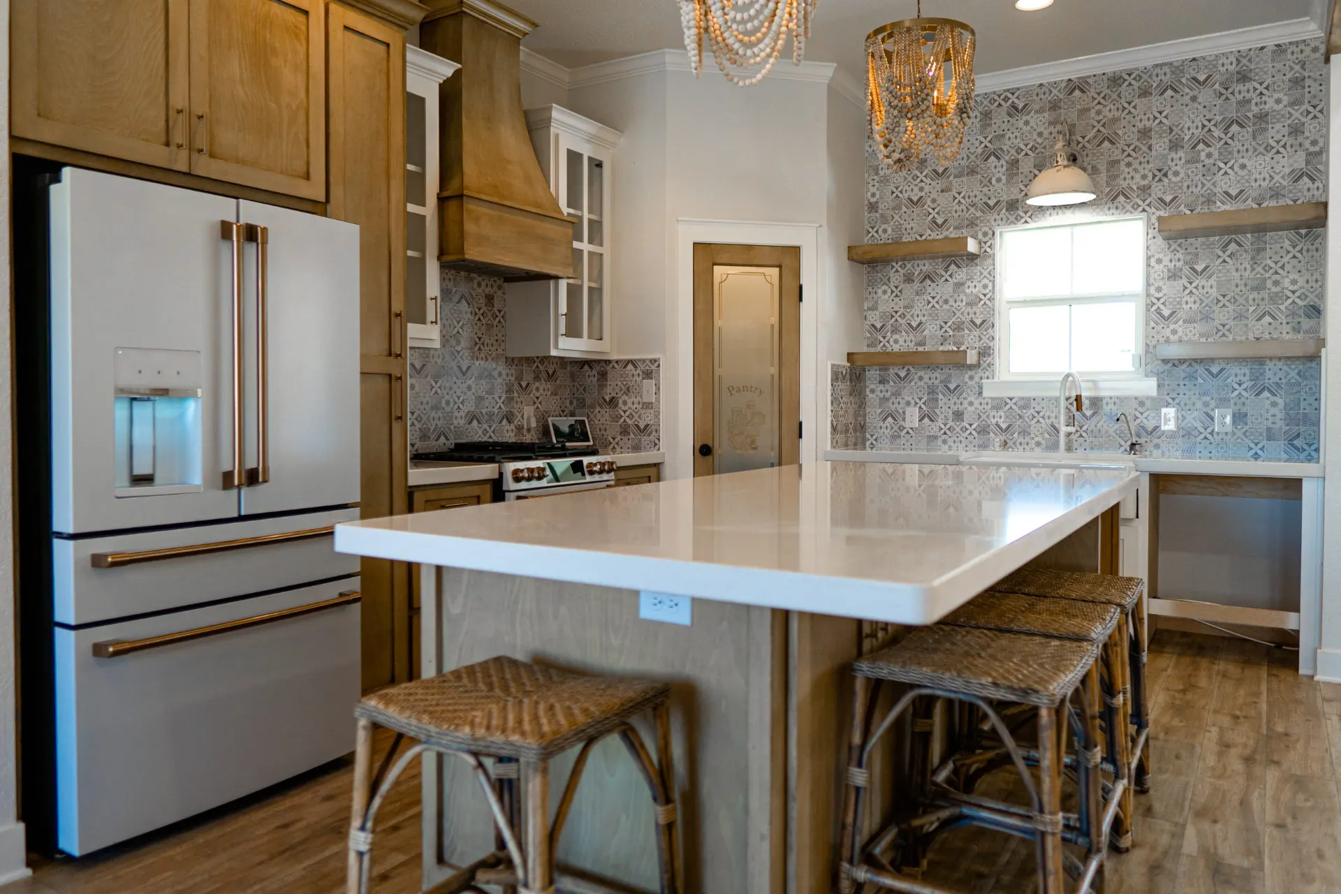 Alternate angle of the Sarai Home kitchen island with an undermount sink, brass hardware and the patterned-tile backsplash wall