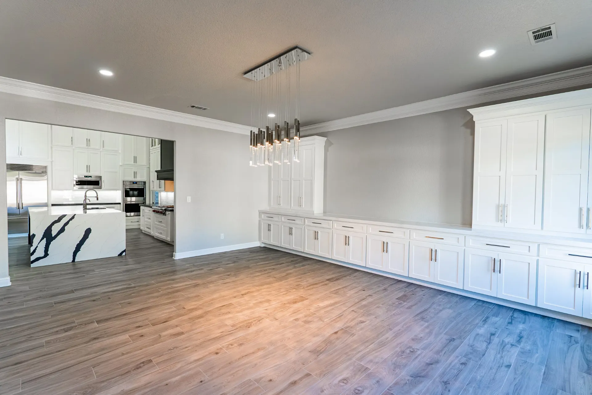 Dining room with a crystal-rod chandelier, built-in buffet and view into the kitchen at 27 Santiago Mission Dr
