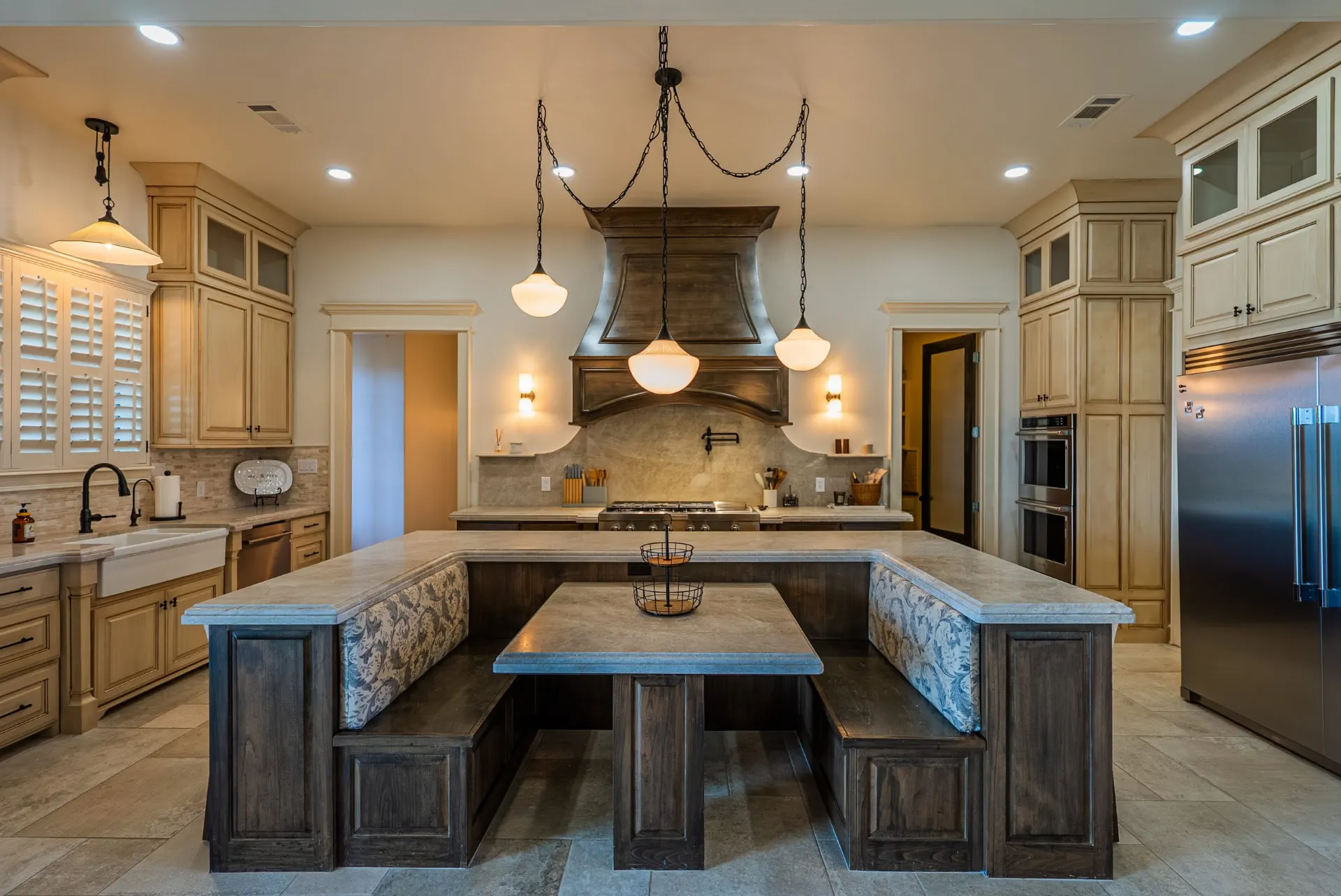 Kitchen at 1610 NW Eliam Dr with U-shaped island, built-in banquette and antiqued cream cabinetry