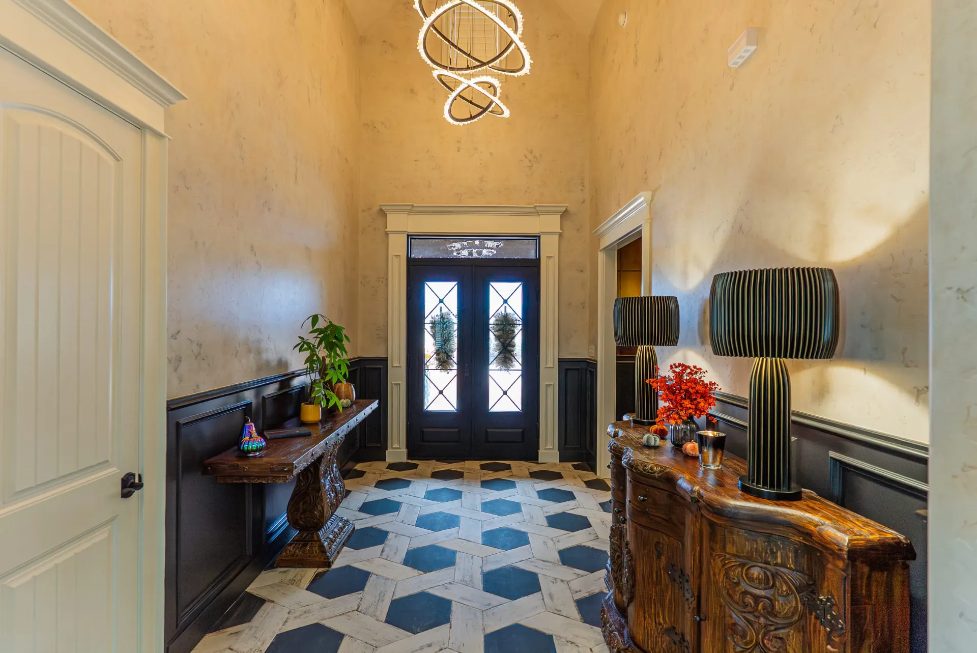 Vaulted entry foyer at 5 Prairie Ln with black double doors and hexagon floor tile