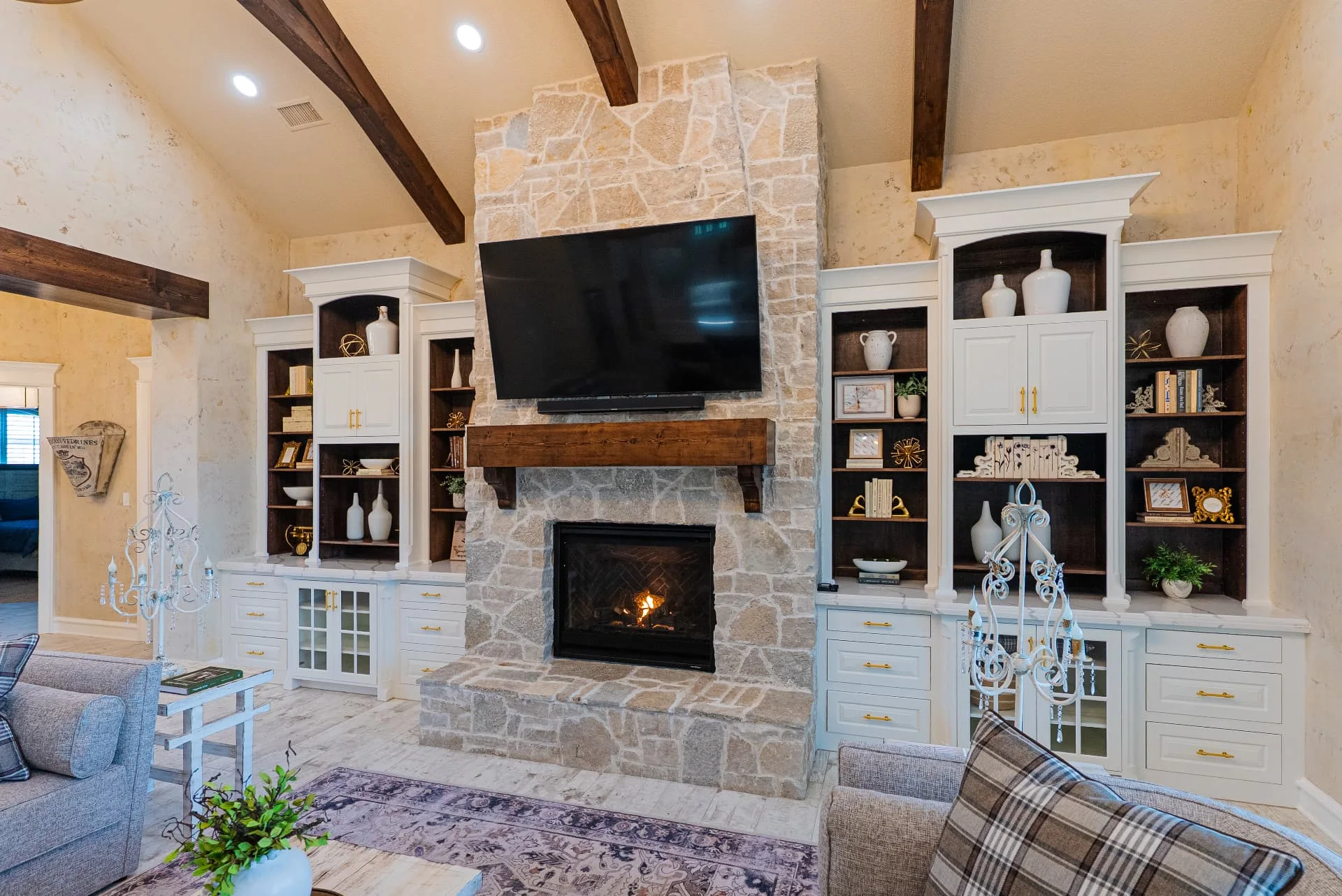 Living room stone fireplace and built-in shelving at The Flores Estate