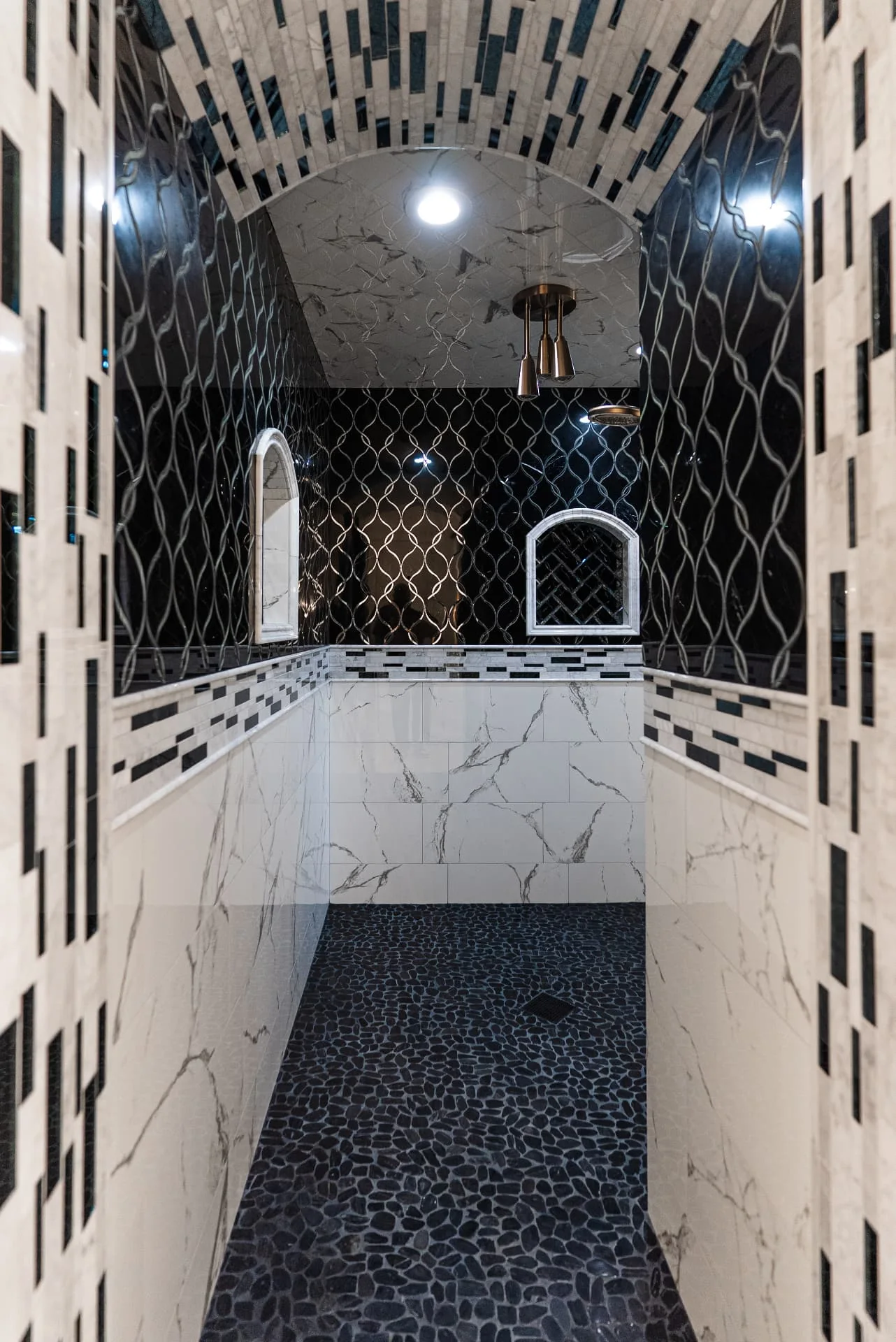 Walk-in shower with stone walls and dark tile at The Flores Estate