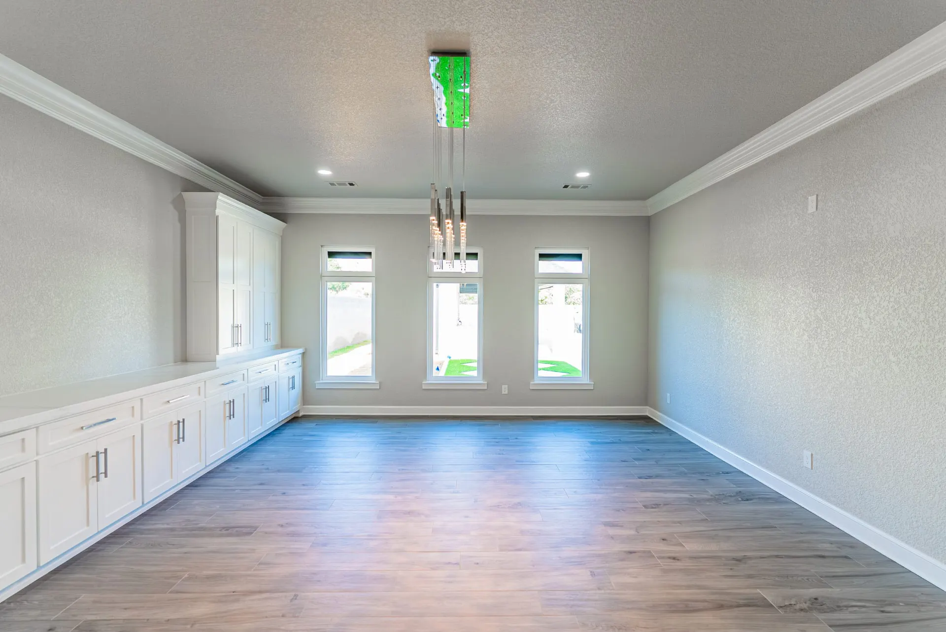 Dining room with a wall of built-in buffet cabinetry and three tall windows at 27 Santiago Mission Dr