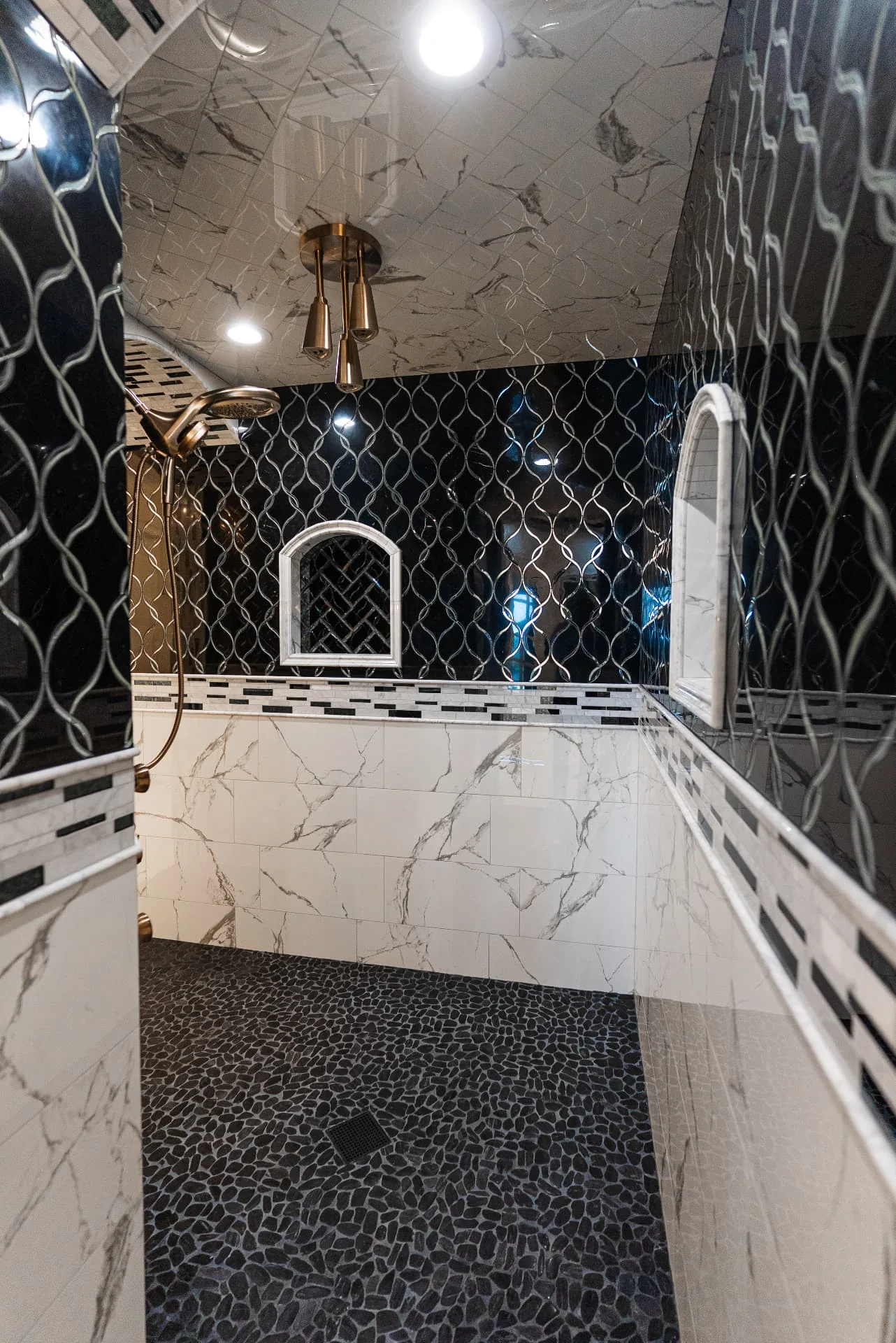 Walk-in shower with dark patterned tile at The Flores Estate