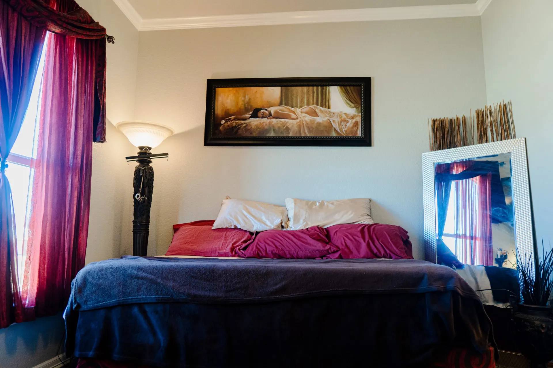 Same bedroom at 8821 Shawn Dr from the foot of the bed, with a black carved floor lamp and a wide framed standing mirror