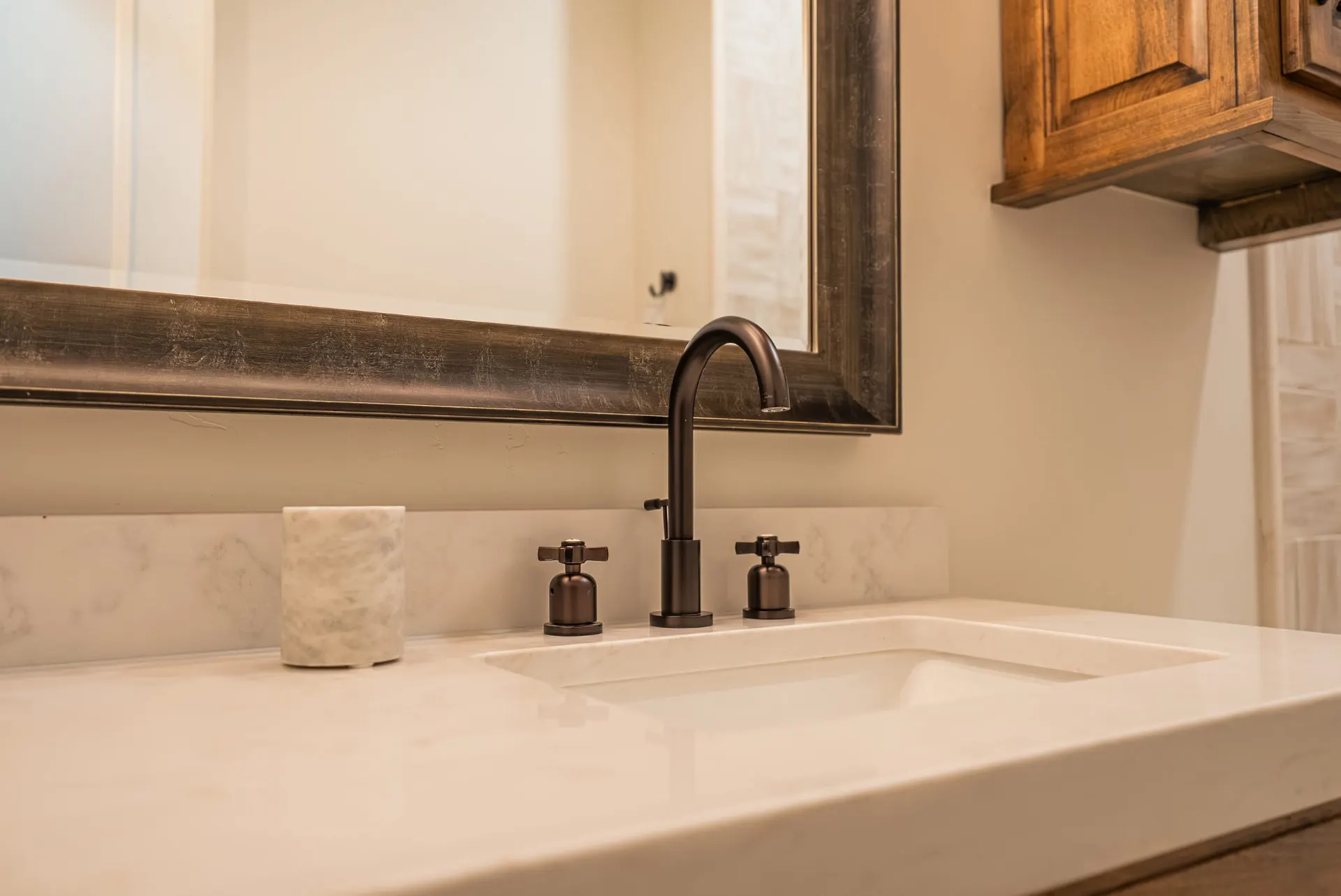 Bronze cross-handle faucet on a quartz vanity at 1610 NW Eliam Dr