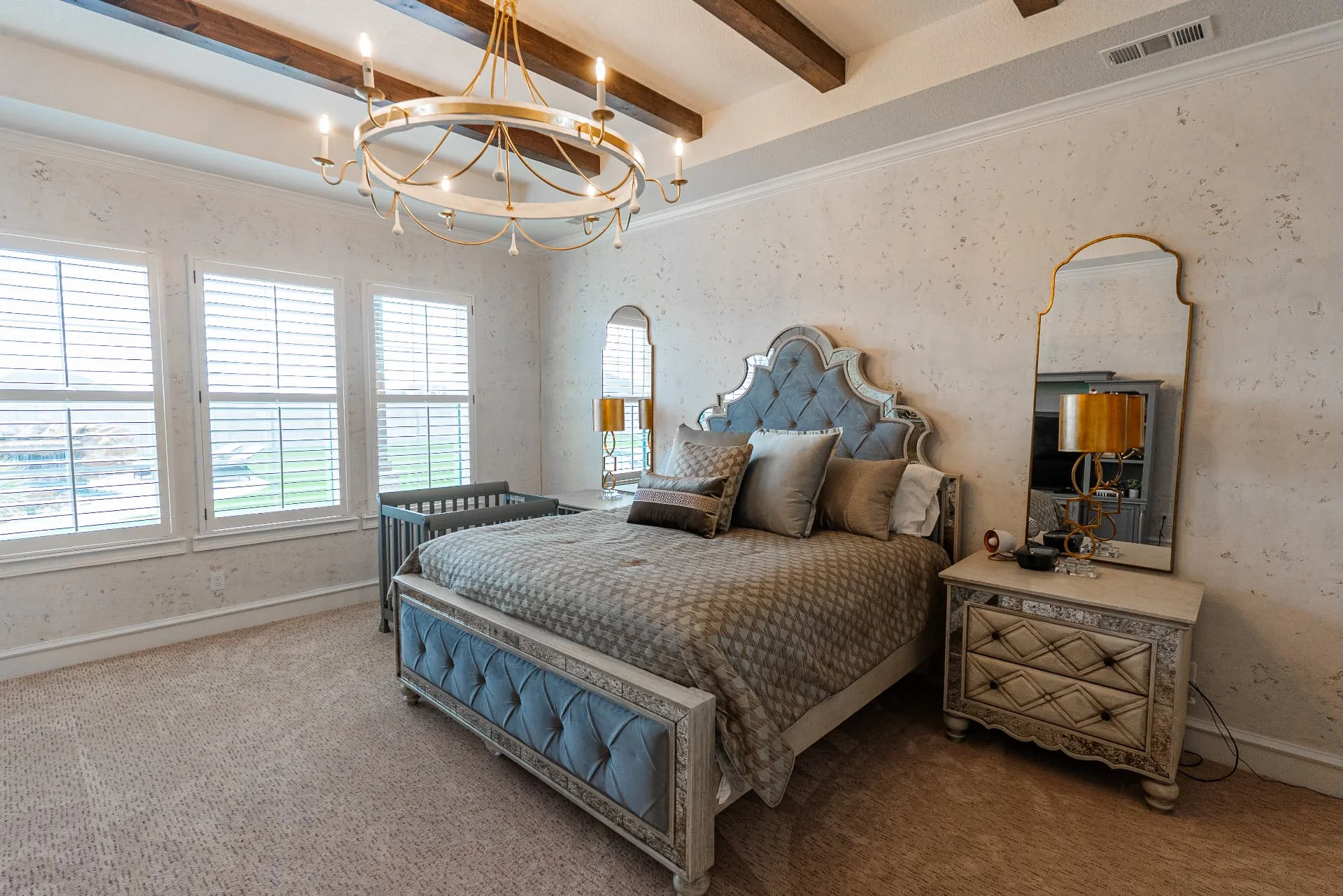 Bedroom with wood ceiling beams and chandelier at The Flores Estate