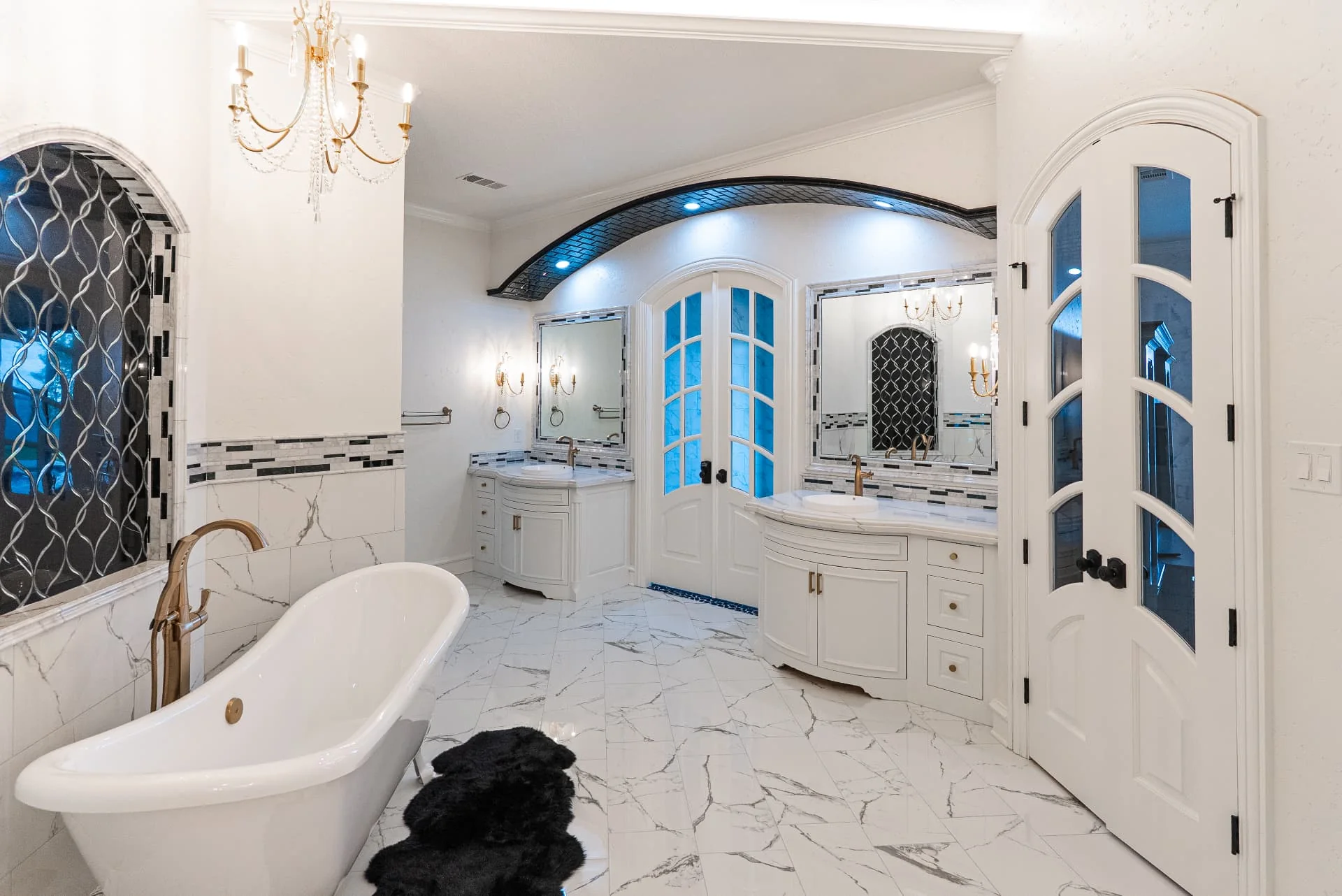 Bathroom tub, vanity and arched mirrors at The Flores Estate