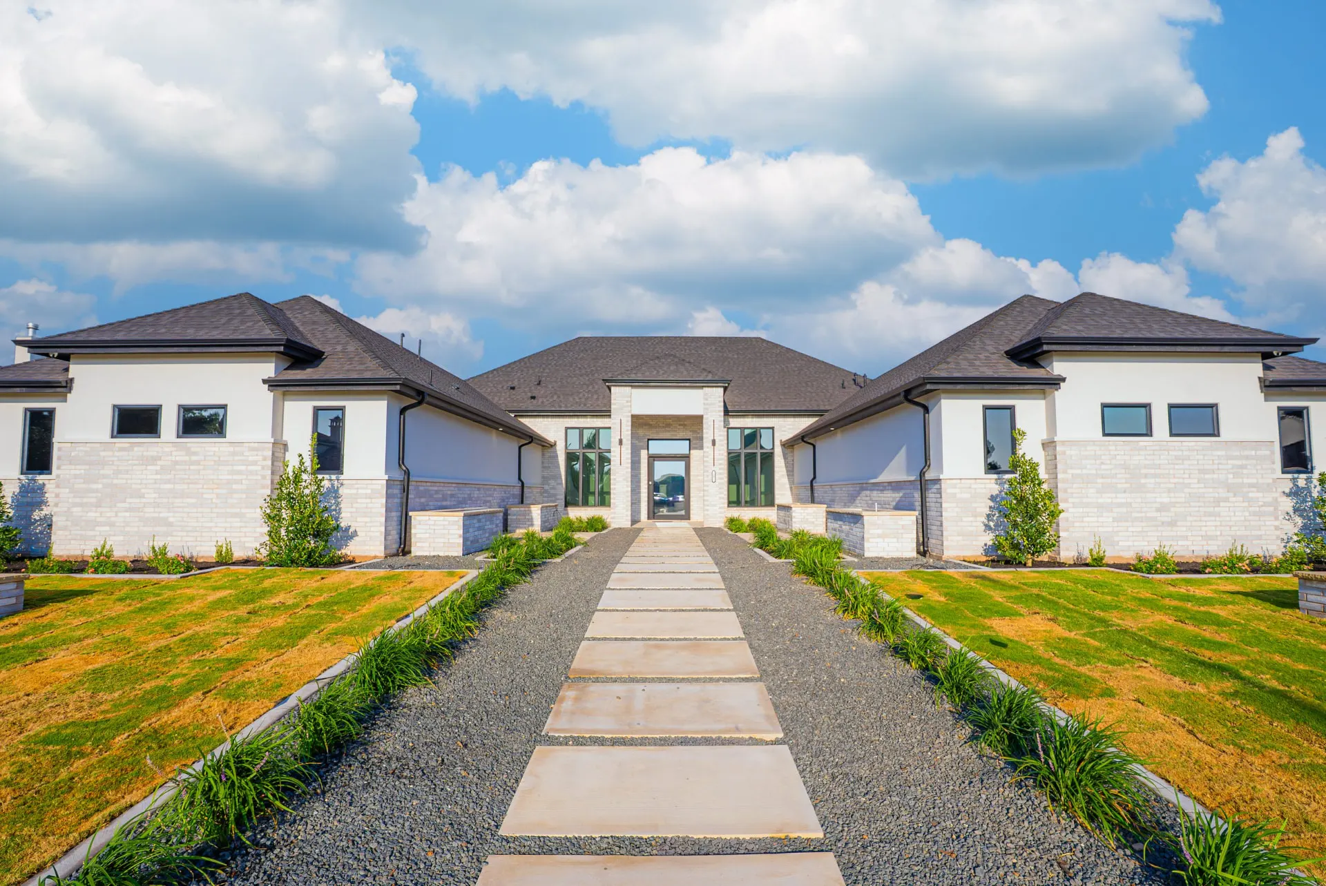 Entry courtyard at 27 Santiago Mission Dr with a stepping-stone walkway, dark gravel beds and ornamental grasses