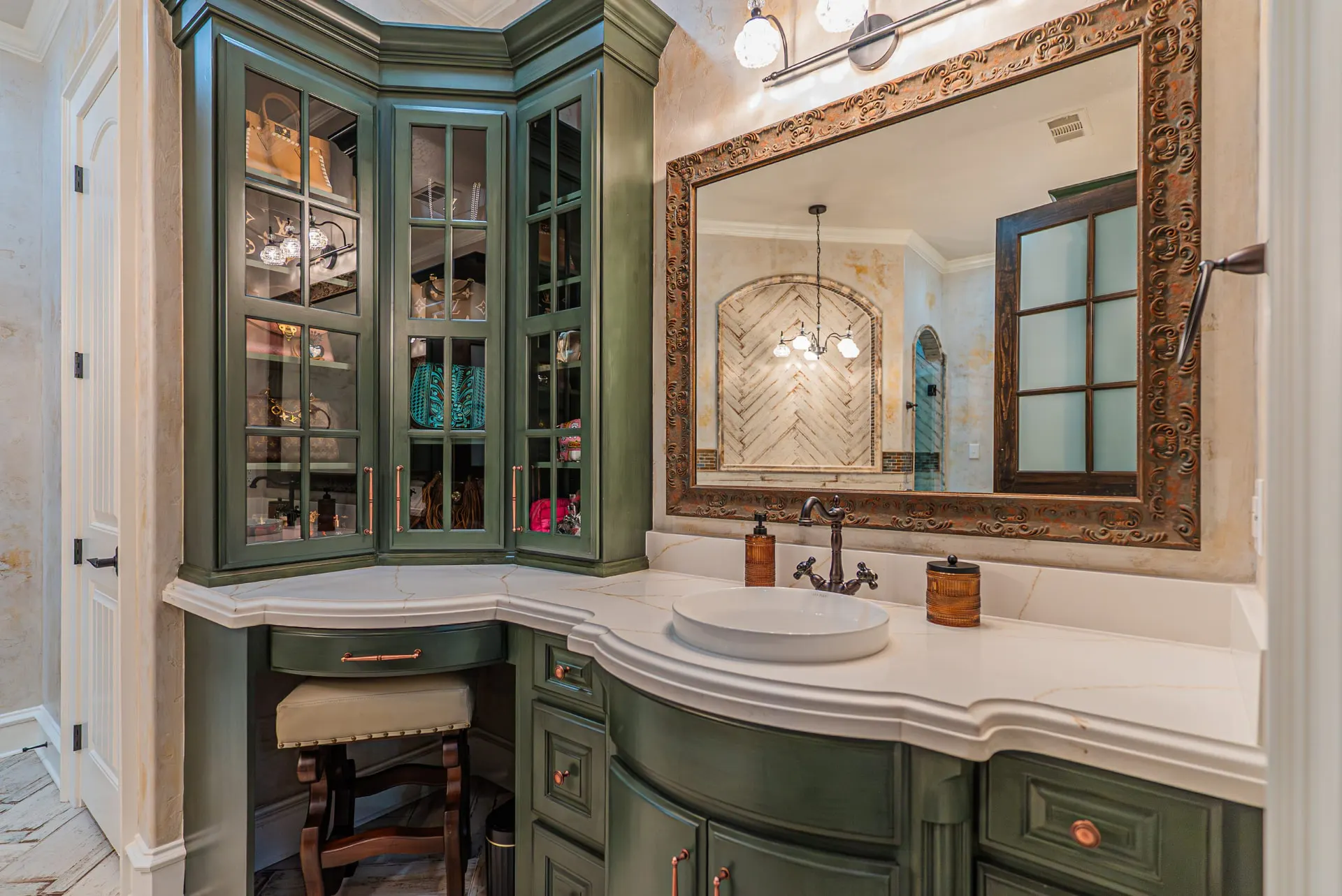 Glam vanity at 5 Prairie Ln in green cabinetry with copper hardware and marble counter