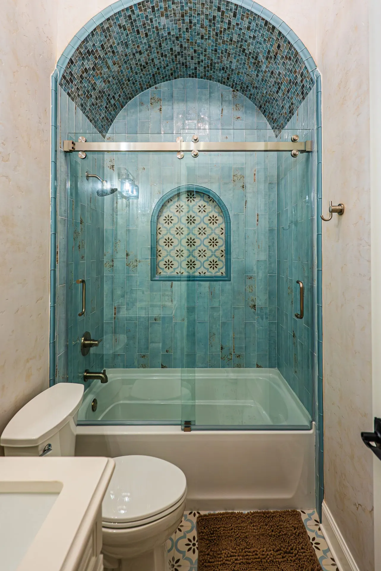 Blue tile tub and shower with arched mosaic ceiling at 5 Prairie Ln