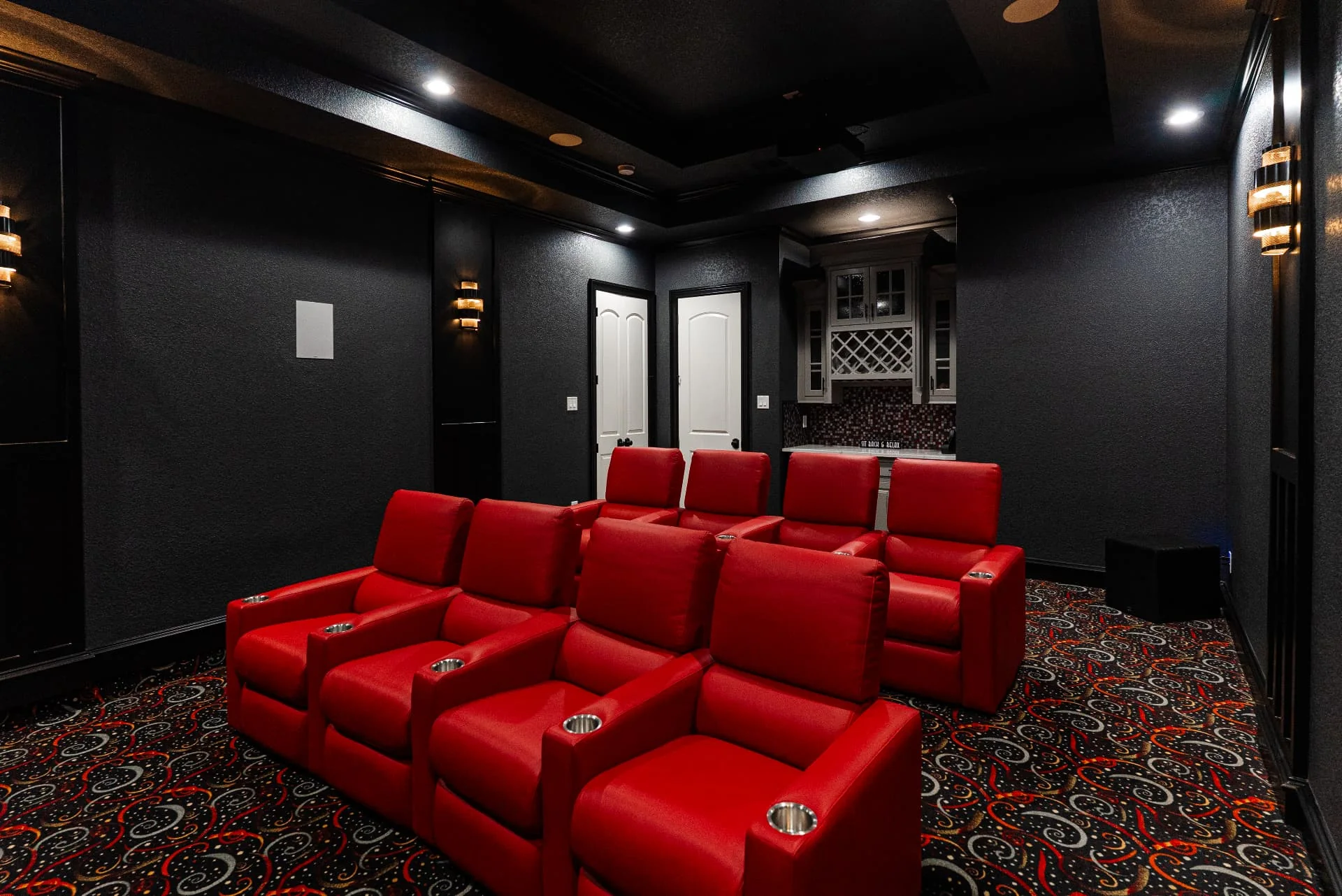 Home theater with red reclining seats at The Flores Estate