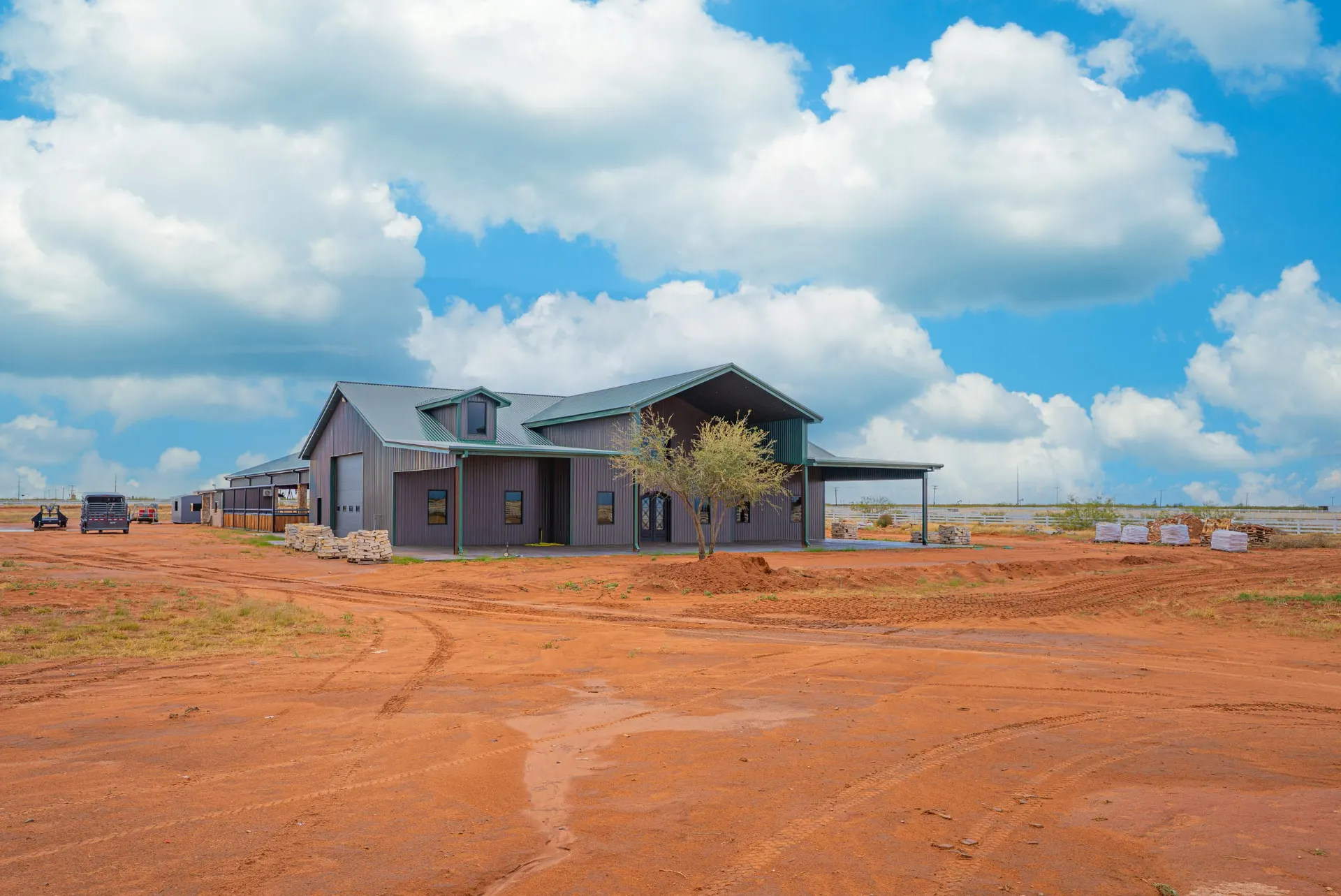 Detached barn and workshop at 5 Prairie Ln with green trim under big West Texas skies