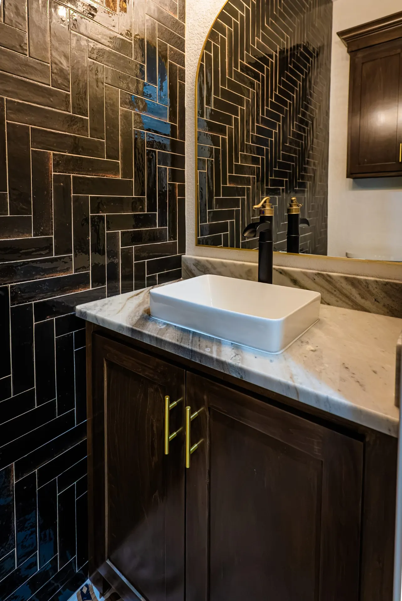 Powder room with black herringbone tile, vessel sink and brass hardware at 1607 NW 12th St