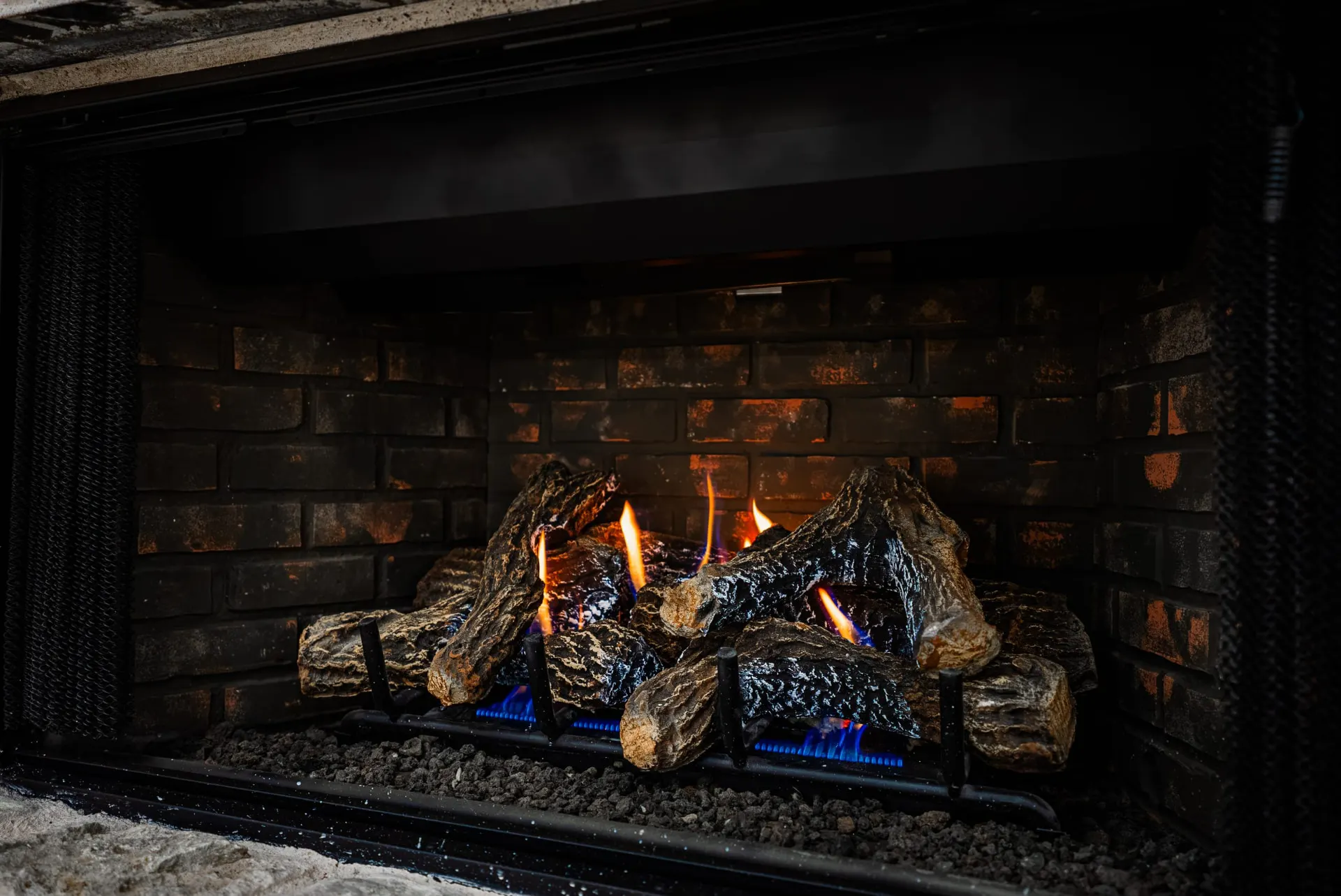Gas fireplace with ceramic logs set in dark brick at 1607 NW 12th St