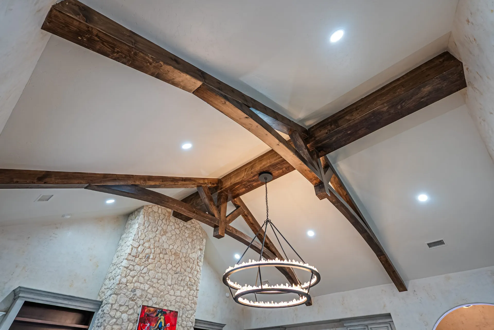 Timber trusses and crystal ring chandelier in the vaulted ceiling at 5 Prairie Ln