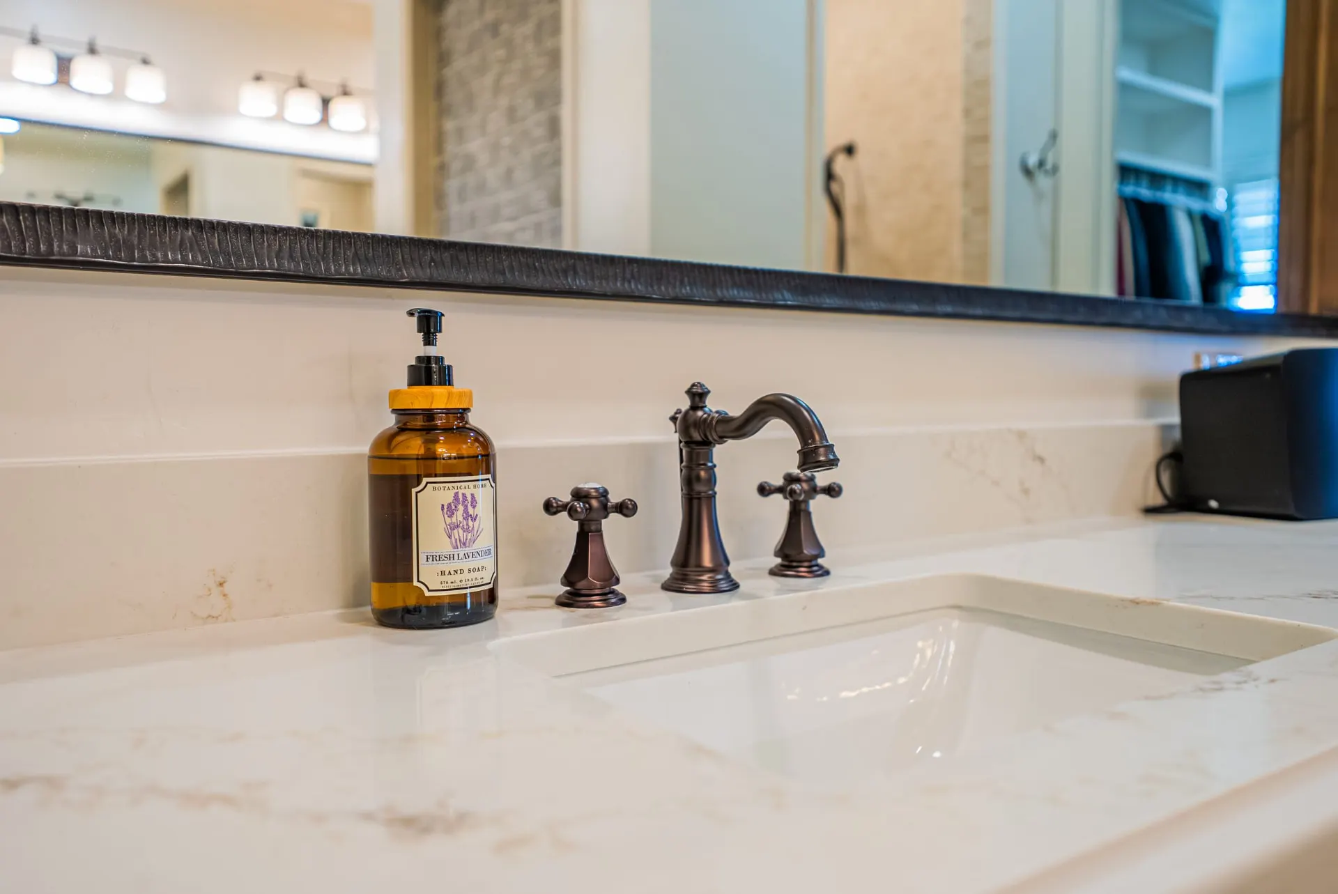 Oil-rubbed bronze cross-handle faucet on a quartz vanity in the primary bath at 1610 NW Eliam Dr