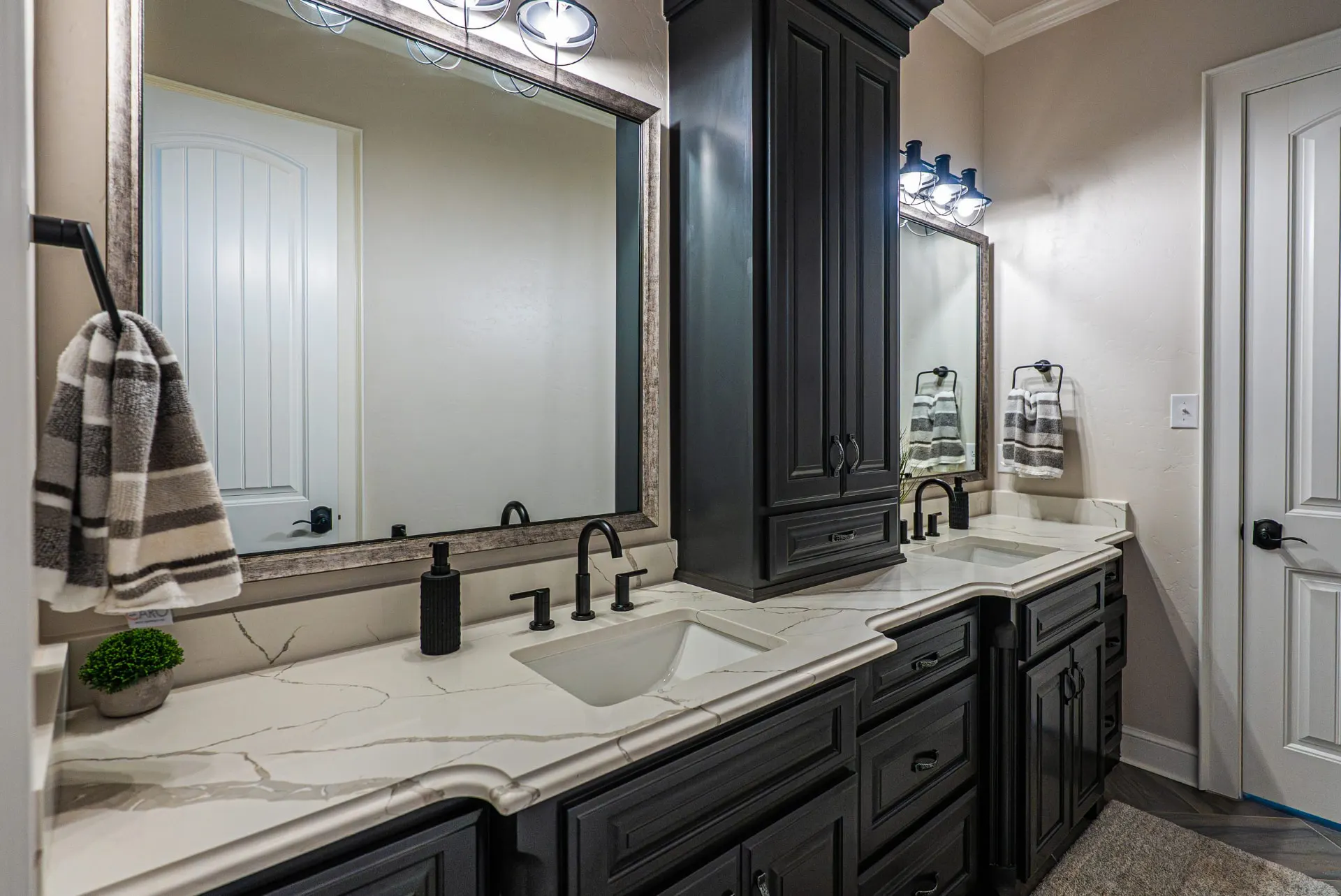 Twin mirrors and black fixtures in the primary bath at 5 Prairie Ln