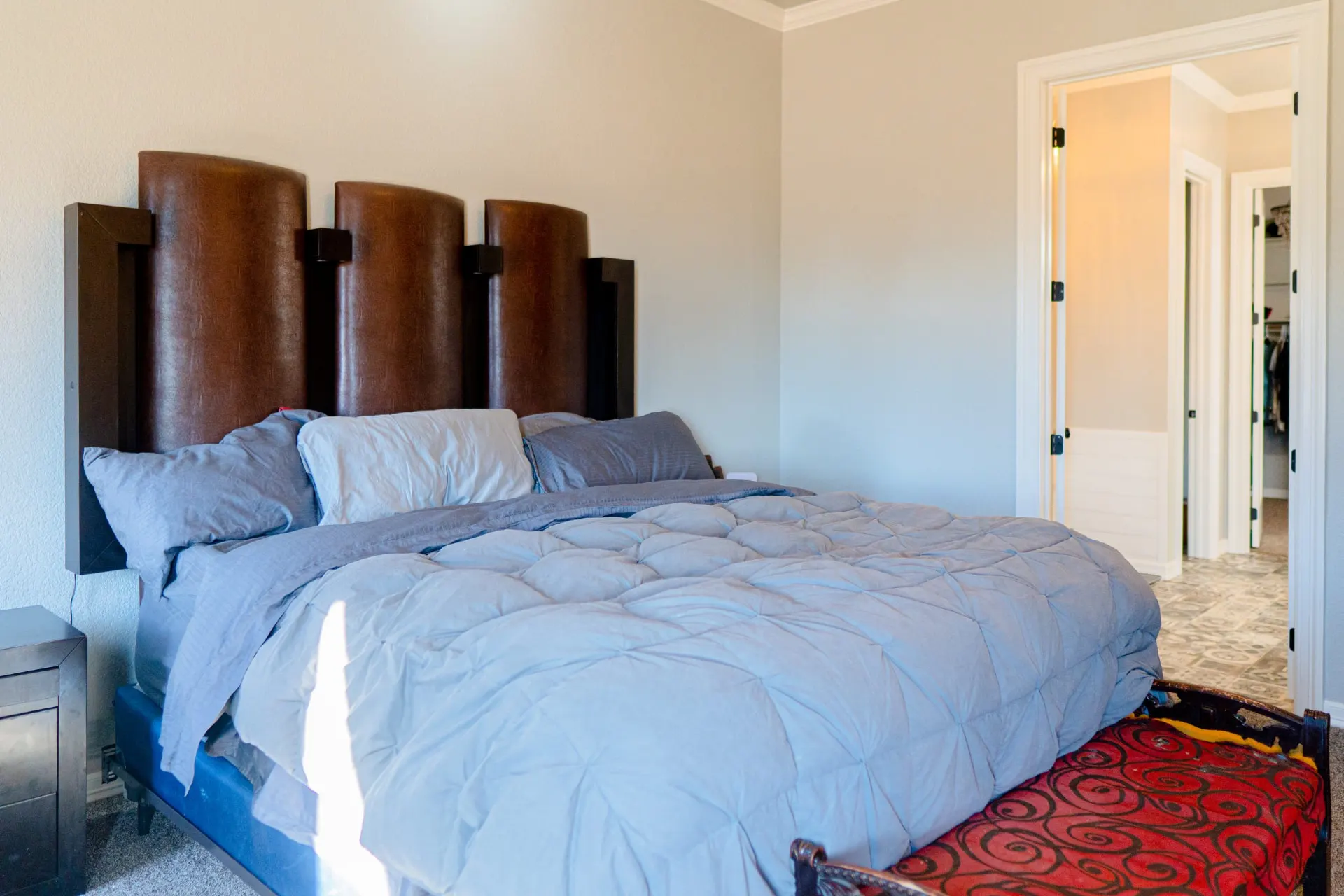 Primary bedroom at 8821 Shawn Dr from the side, with an open doorway to an ensuite with patterned tile flooring and a walk-in closet beyond