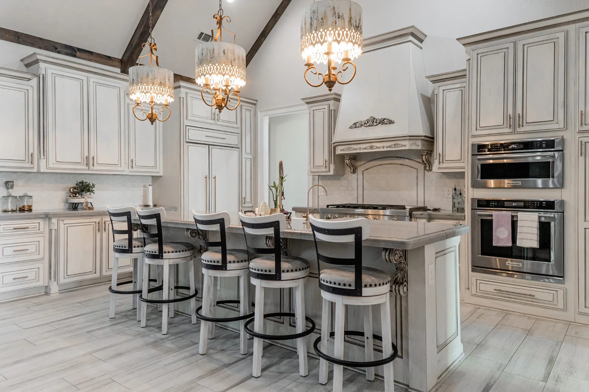 Wide view of the 1667 Eldenrod kitchen with island bar seating, double wall ovens and glazed cabinetry