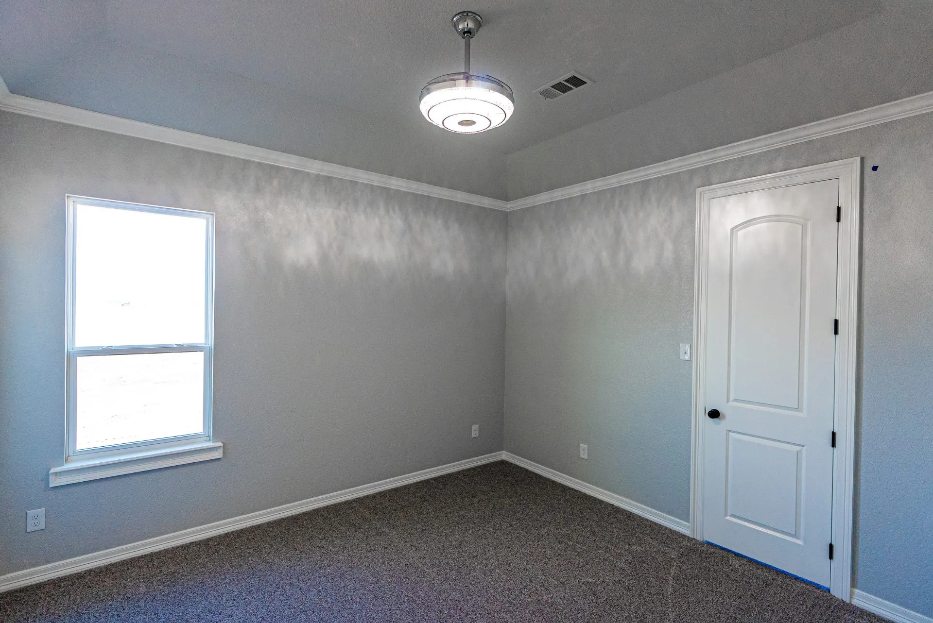 Carpeted bedroom at 1511 NW 12th St with a crystal ceiling fixture and large sunny window