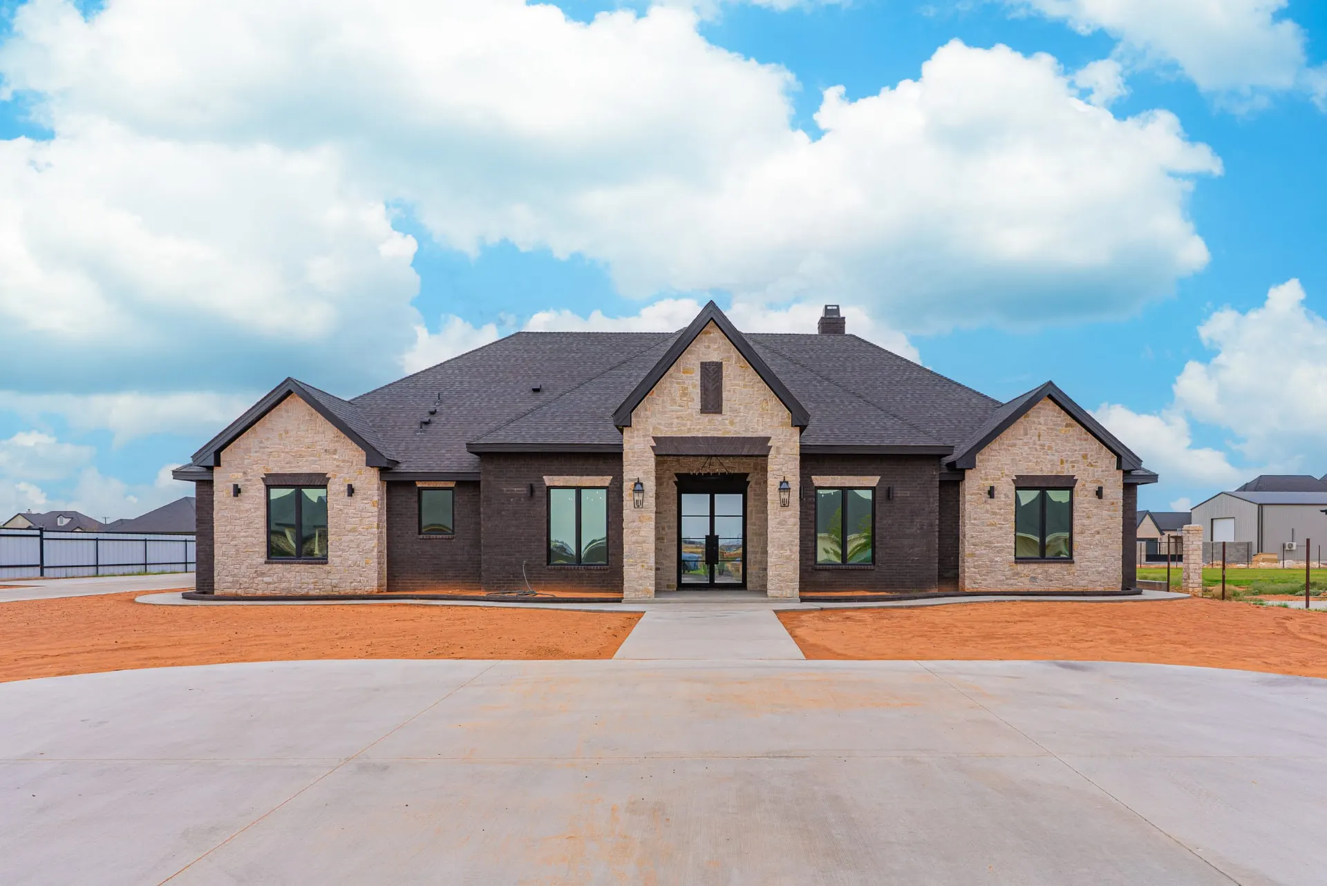 Front elevation of 1607 NW 12th St — limestone gables, dark brick and a black steel-glass entry