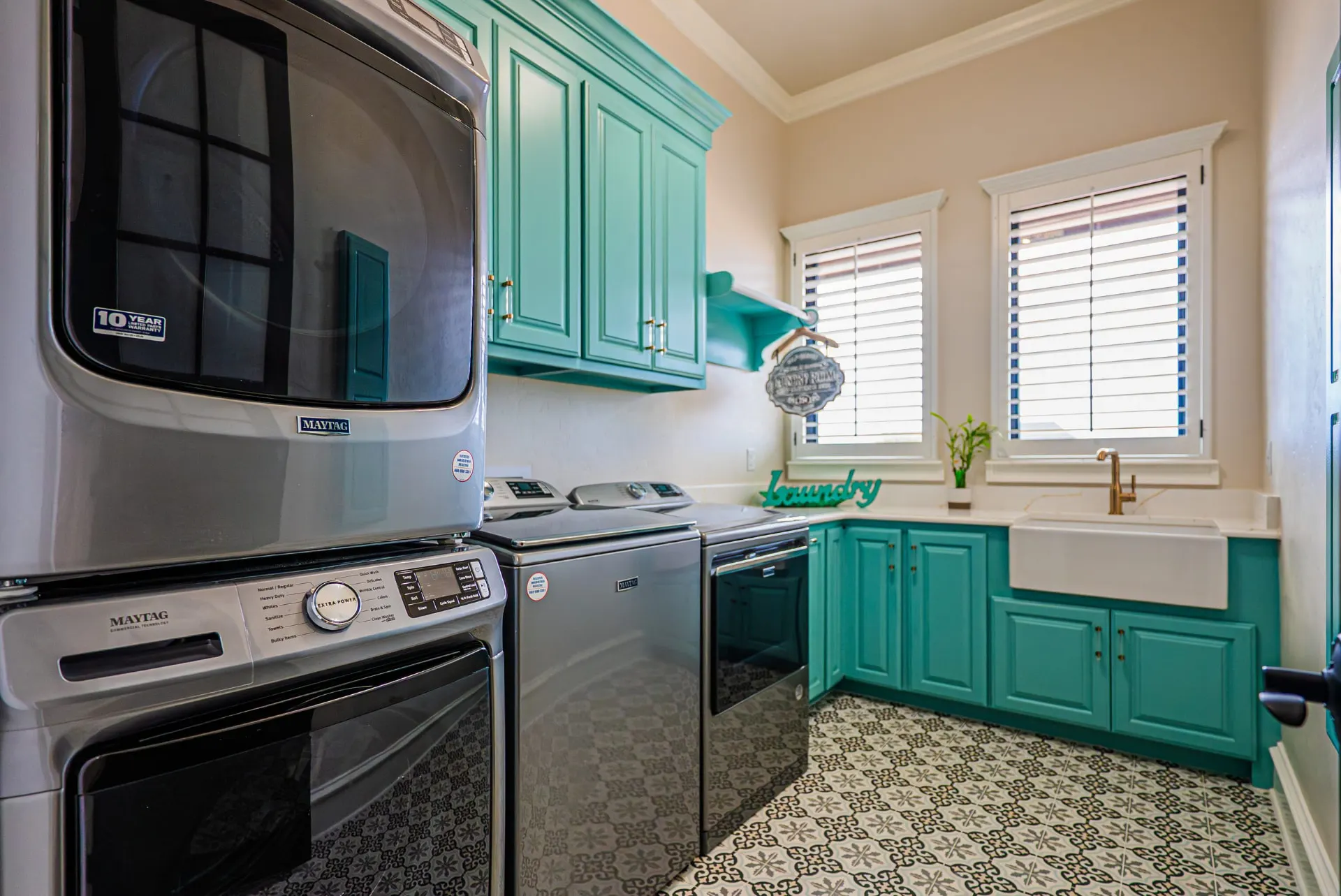 Laundry room at 5 Prairie Ln in teal cabinetry with farmhouse sink