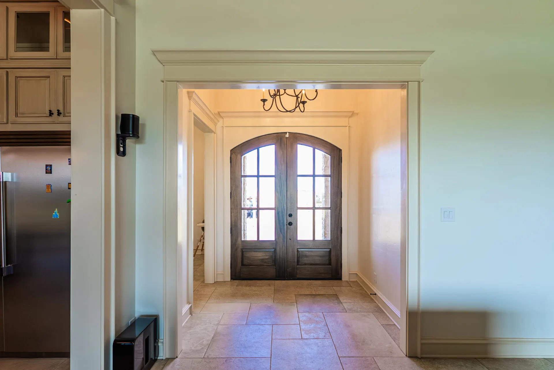 Entry at 1610 NW Eliam Dr with arched dark double front doors and a black metal chandelier