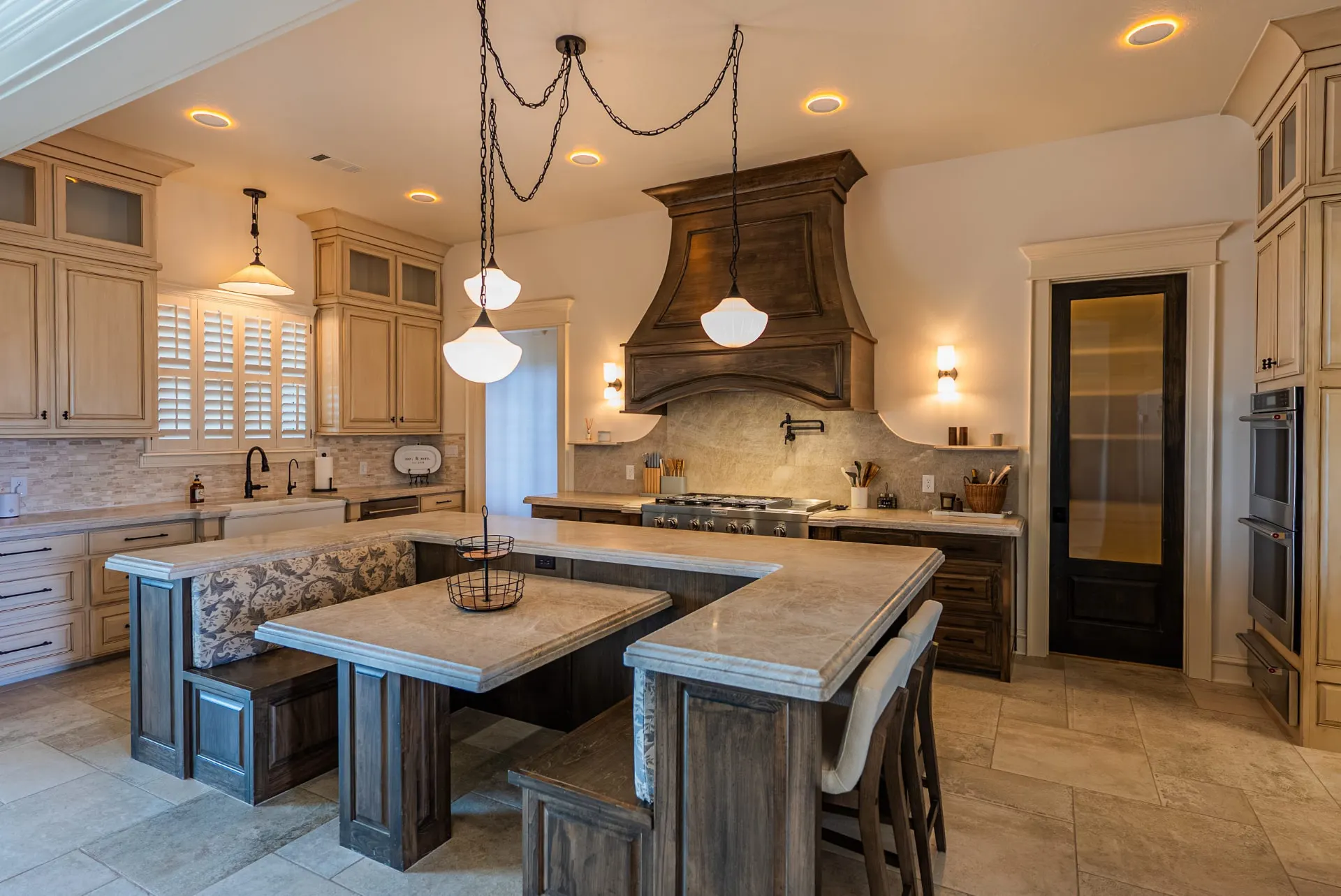 Kitchen at 1610 NW Eliam Dr with dark wood island, carved range hood and shuttered windows