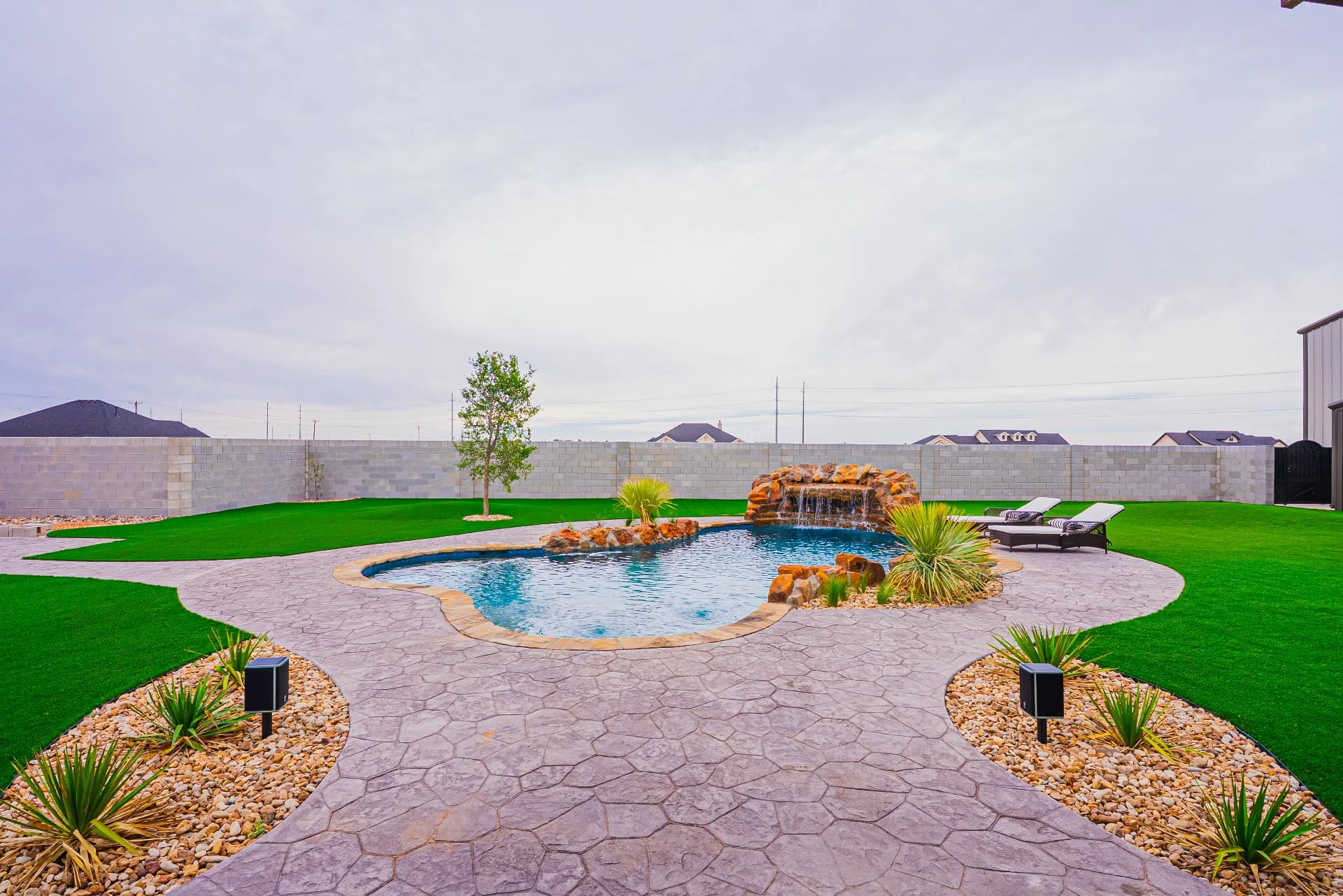 Pool, stone paving and lawn at The Flores Estate